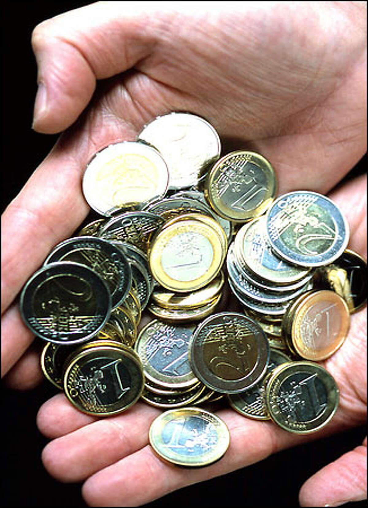 One-euro and 2-euro coins like these are the new money of millions.