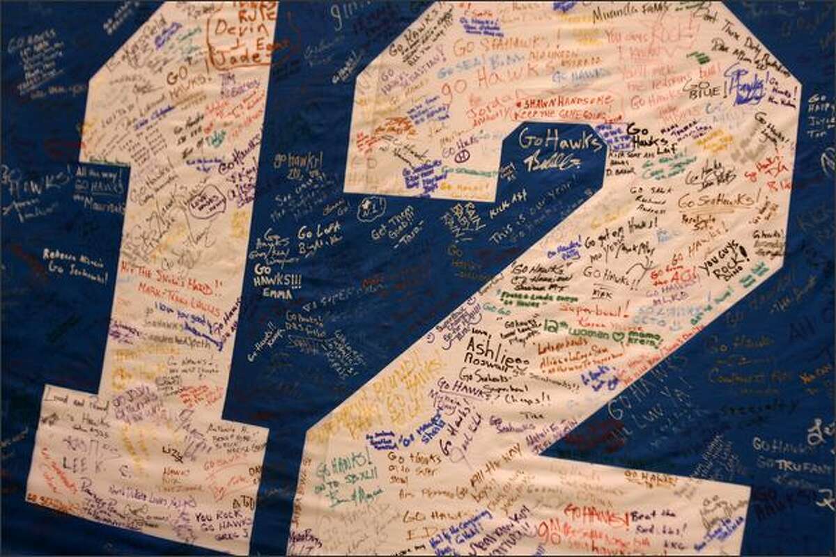 Dozens of fans signed a 12th Man flag at a Seahawks pep rally at Qwest Field on Friday.