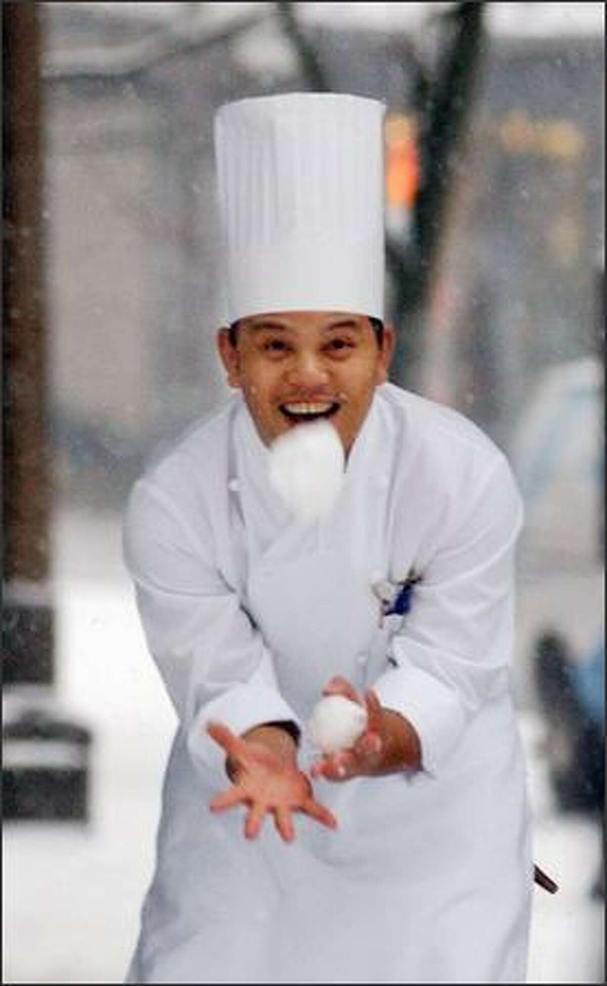 Chef Leo Bonilla tries to catch a snowball thrown at him by a co-worker at the downtown Seattle Sheraton hotel Tuesday morning. The snow closed schools and persuaded many commuters to stay home. (AP Photo/Elaine Thompson)