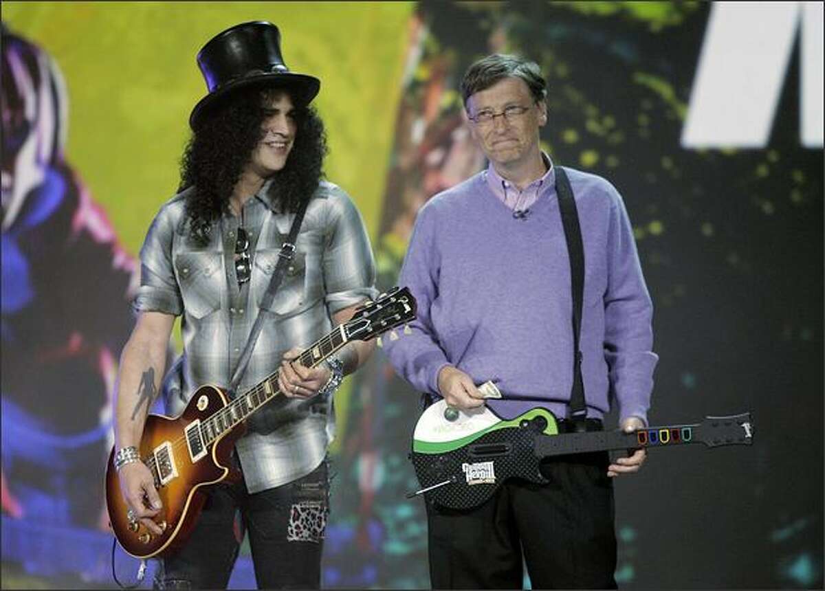 Microsoft chairman Bill Gates, right, introduces guitarist Slash as his ringer in a friendly "Guitar Hero" match against Robbie Bach, president of Microsoft's Entertainment and Devices Division, during Gates' keynote at the 2008 Consumer Electronics Show.