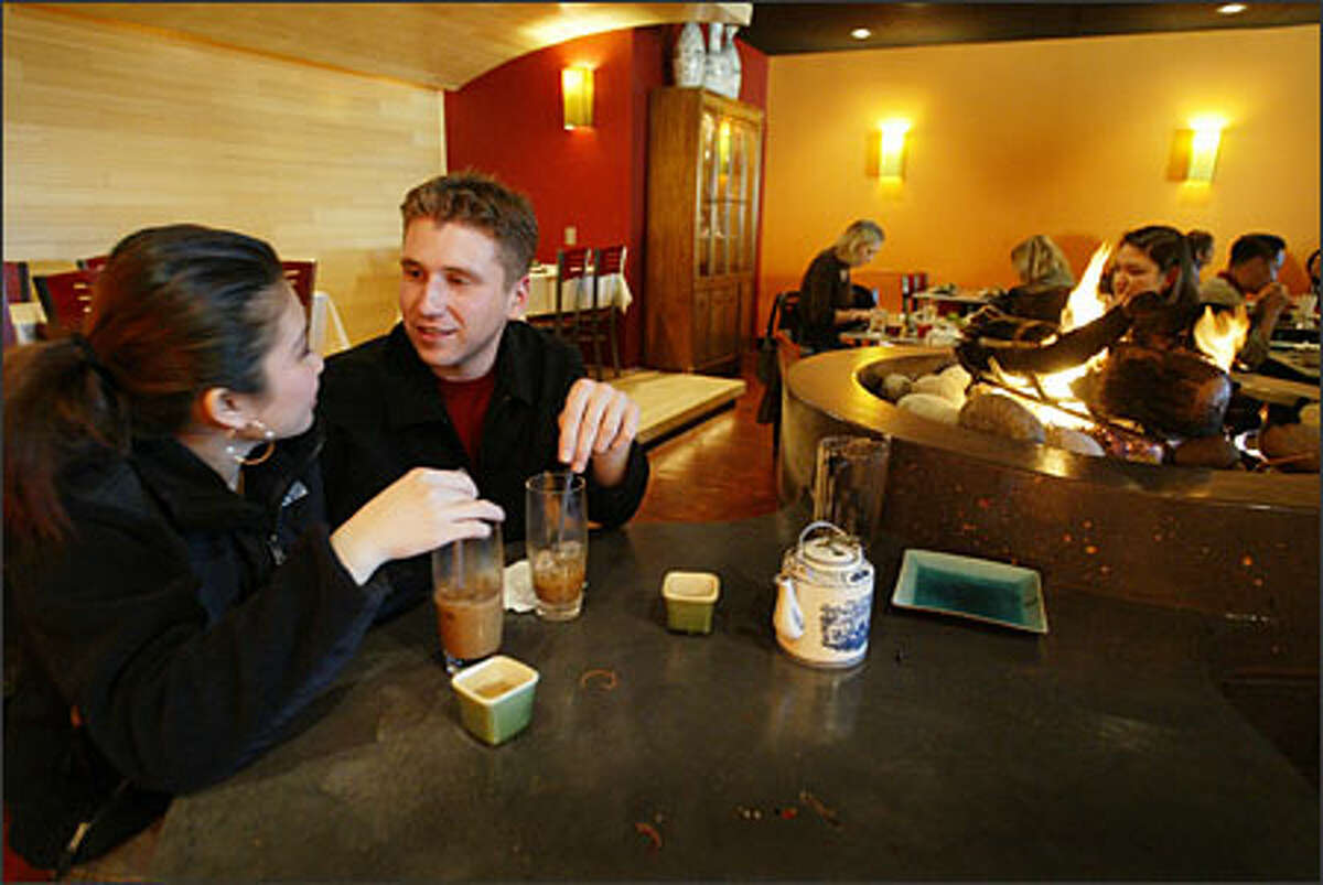 Cindy Pham and Ian McKamey find a quiet spot by the fire pit for their first visit to Tamarind Tree Vietnamese restaurant in the Little Saigon area of Seattle's International District.