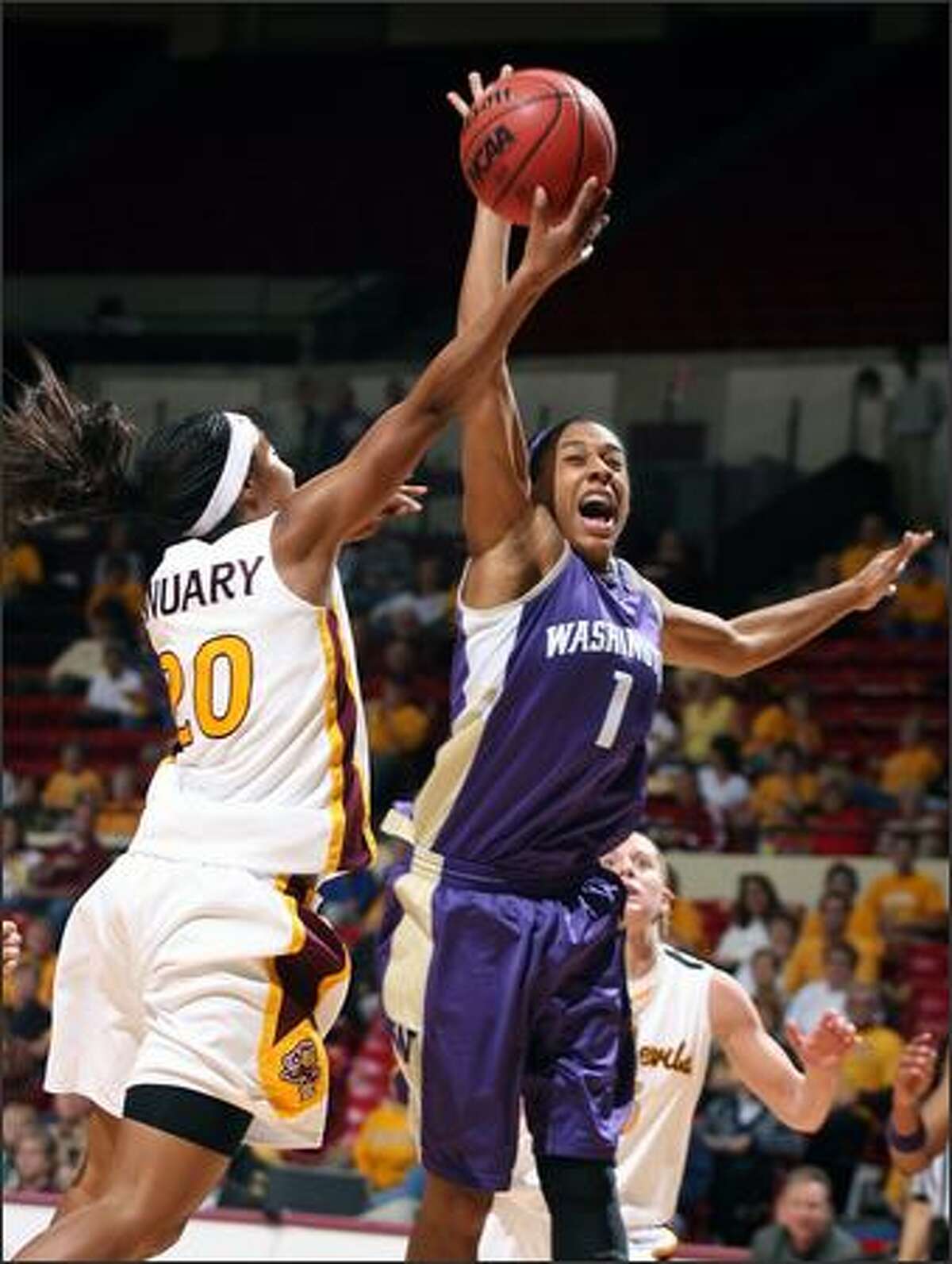 Washington's Jill Bell blocks a shot attempt by Arizona State's Briann January in the first half