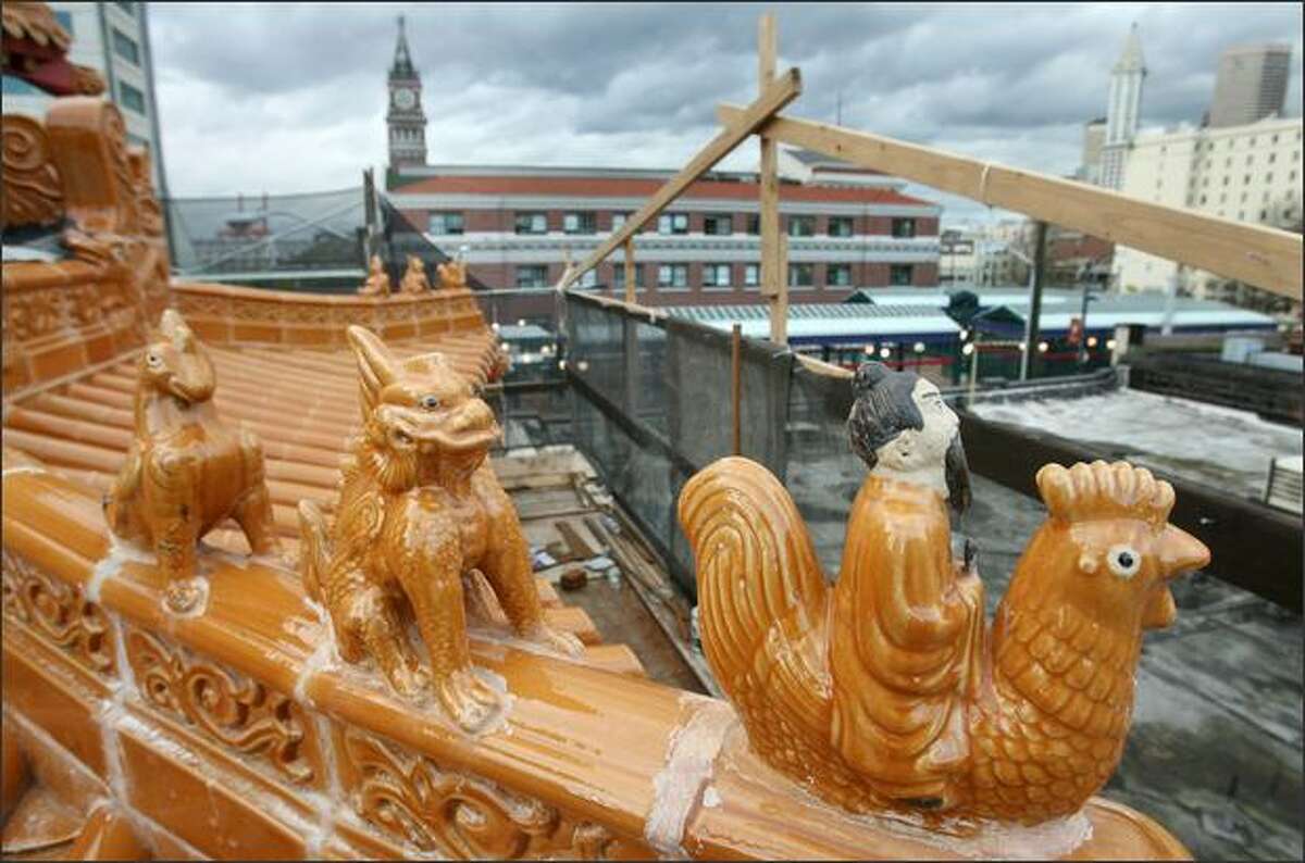 Animals such as a dragon and a phoenix atop a new gate under construction in Chinatown are said to keep away bad luck and welcome a flow of good air.
