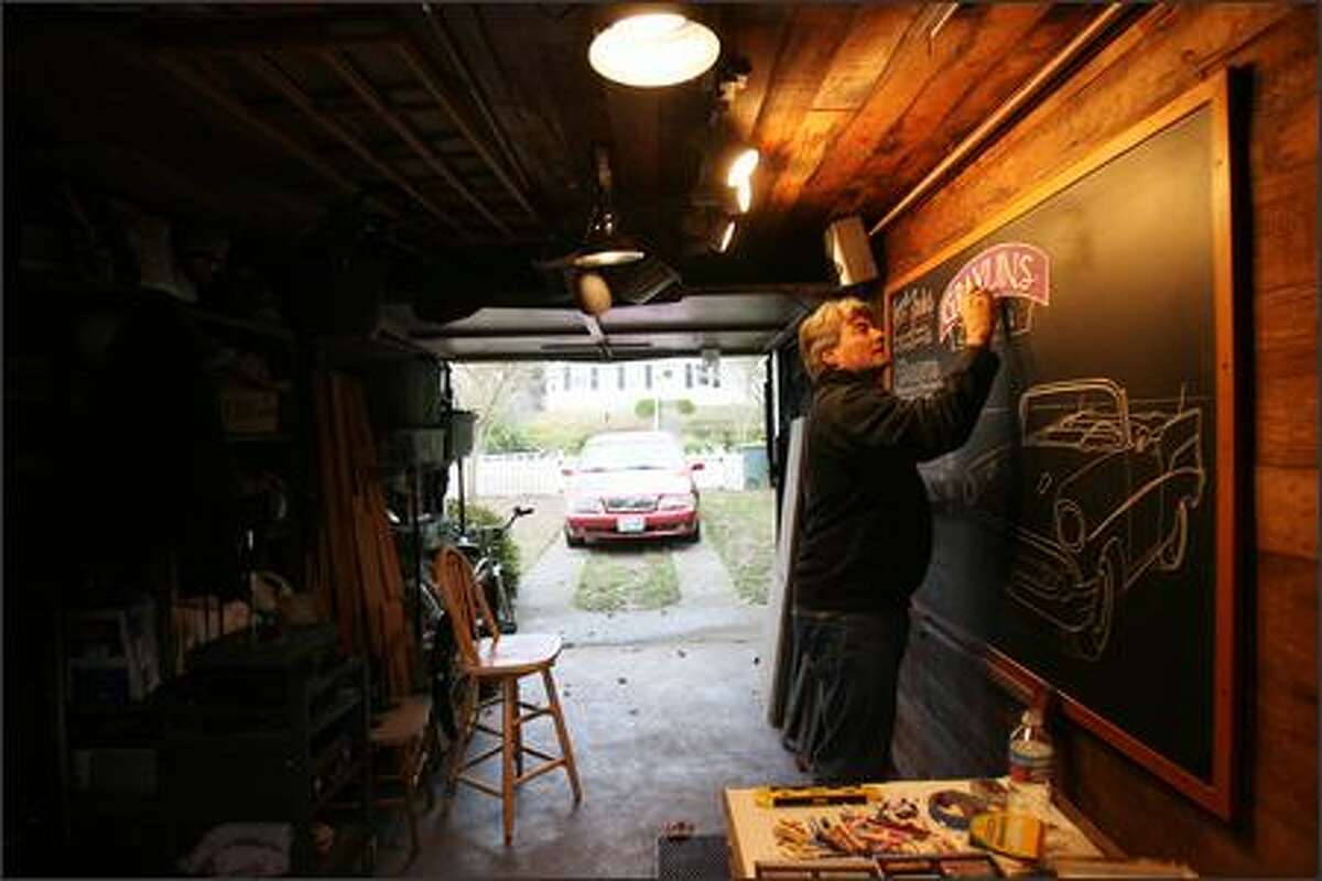 John Rozich illustrates a chalkboard for a Detroit restaurant in his Magnolia "studio," the garage. Classic cars are one of his favorite subjects.