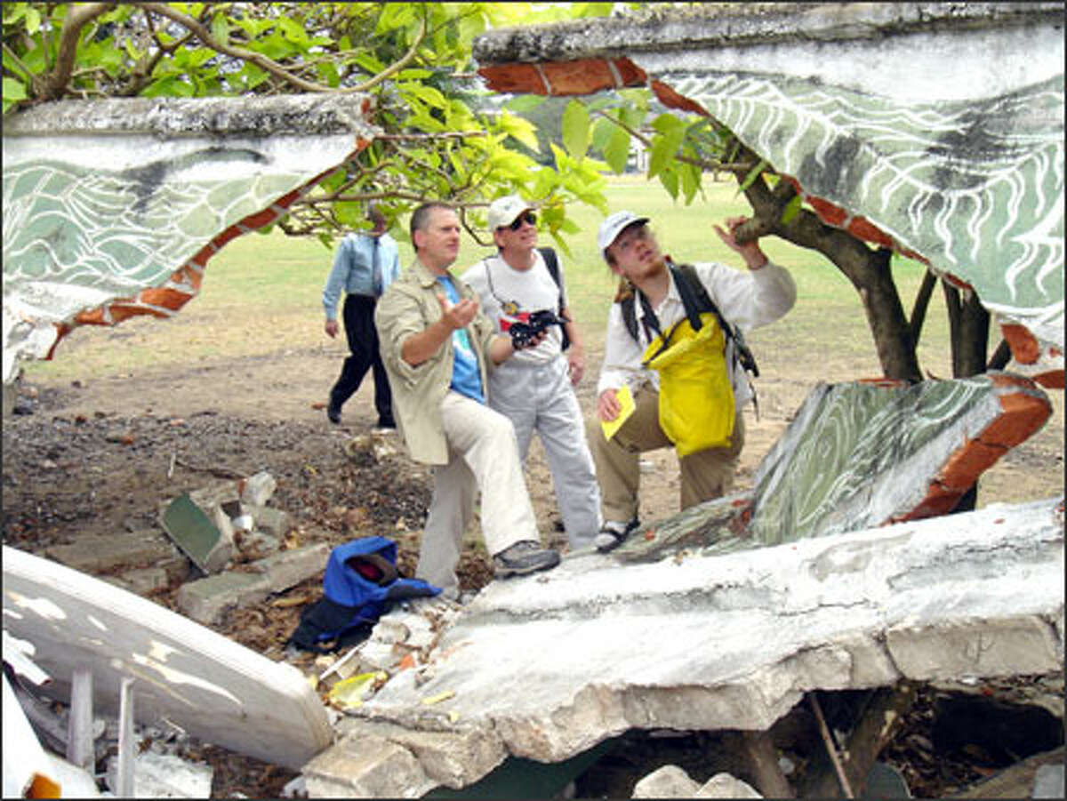 Tsunami researchers James Goff, Robert Morton and Bretwood Higman examine a wall damaged by the tsunamis Dec. 26 in Colombo, Sri Lanka.