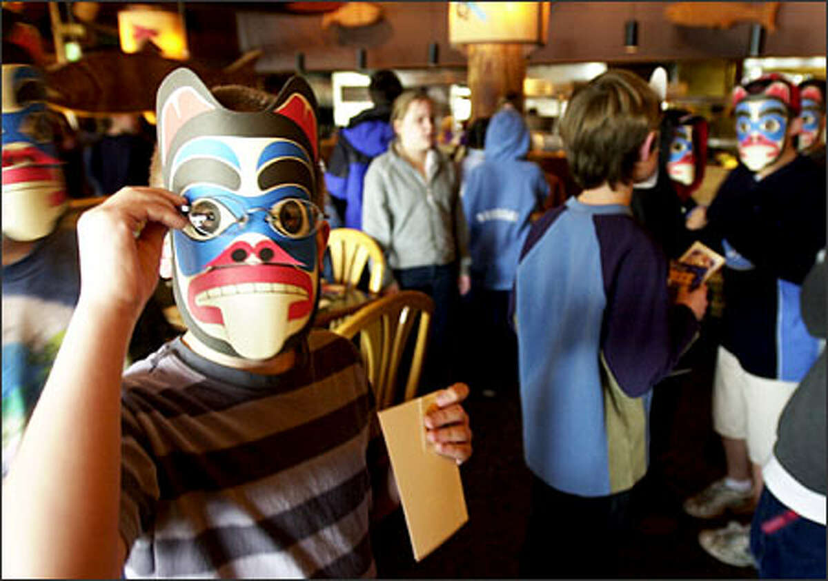 Pupils from Hazelwood Elementary School in Newcastle don Native American masks that were handed out yesterday at Ivar’s Restaurant in Seattle as part of the "Salmon in the Classroom" program.