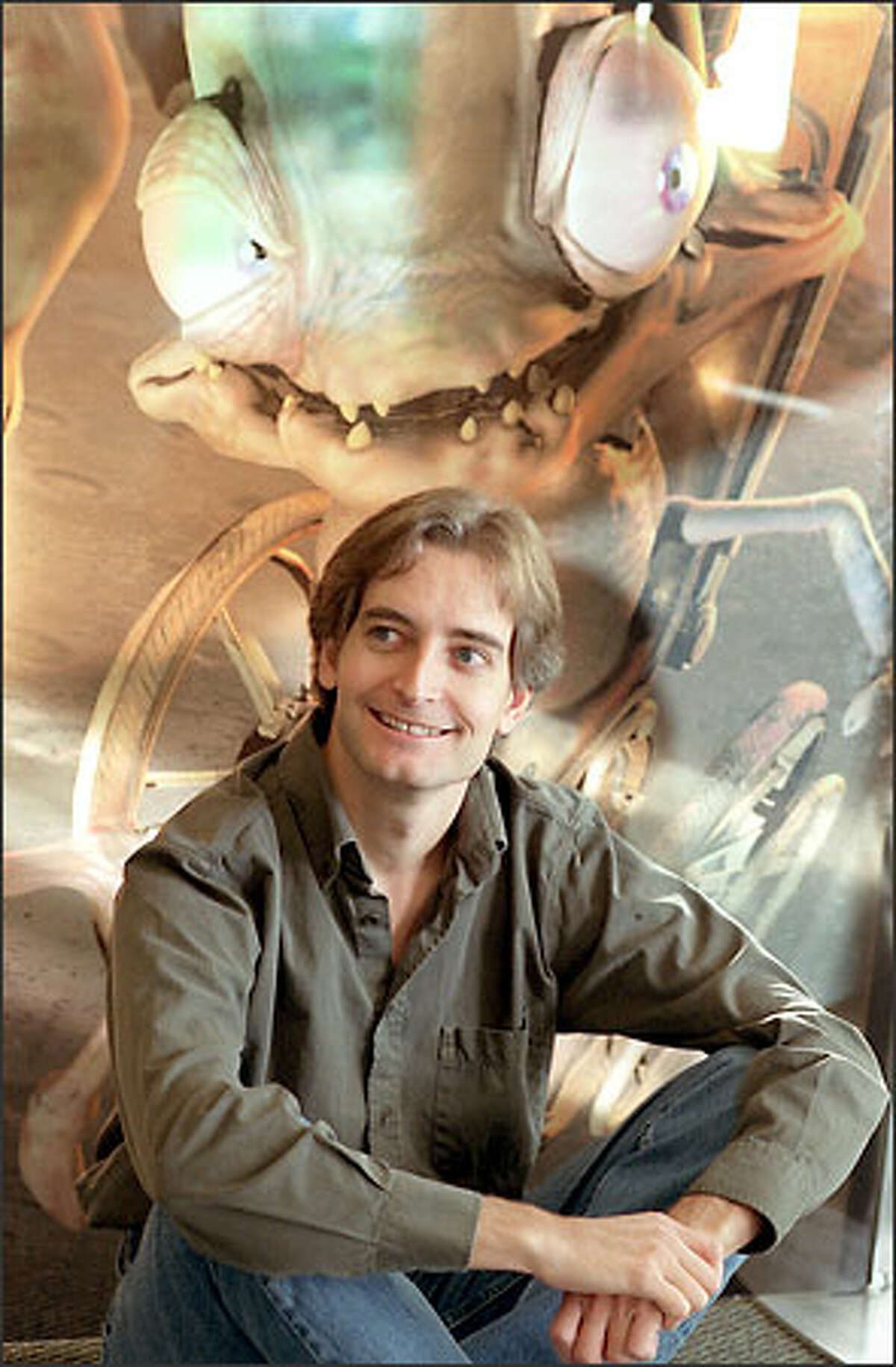 Ed Fries, vice president of game publishing at Microsoft, sits in front of a photo of Munch, a character from "Oddworld: Munch's Oddysee," an Xbox game. Fries is leaving after 18 years with the company, but he isn't ready to talk about what he might do next.