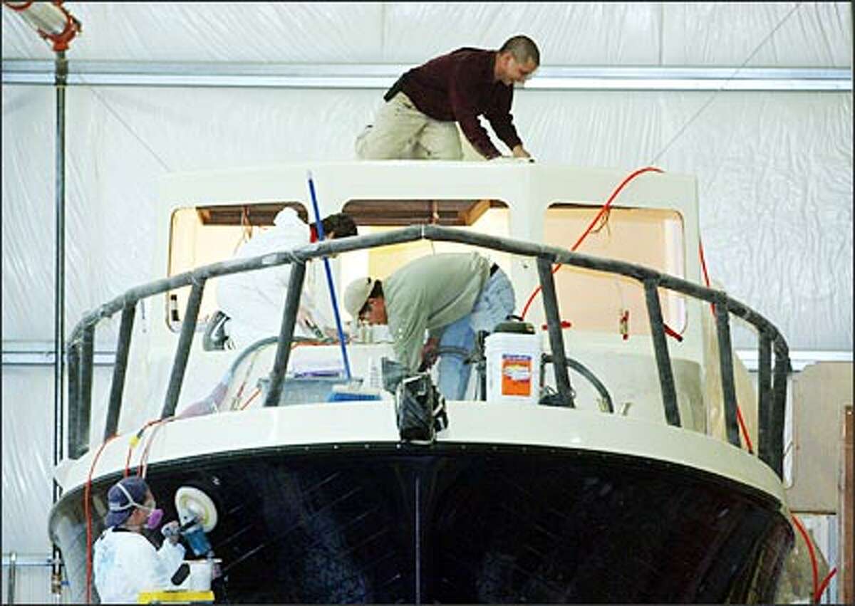 Employees from Tomco Marine Group in La Conner work on American Tug 34, a 34-foot luxury craft that sells for $317,000. It will be on display at the Lake Union Boats Afloat Show (www.boatsafloatshow.com), which showcases more than 175 sail and motor yachts starting Friday at Chandler’s Cove. Tickets cost $10.