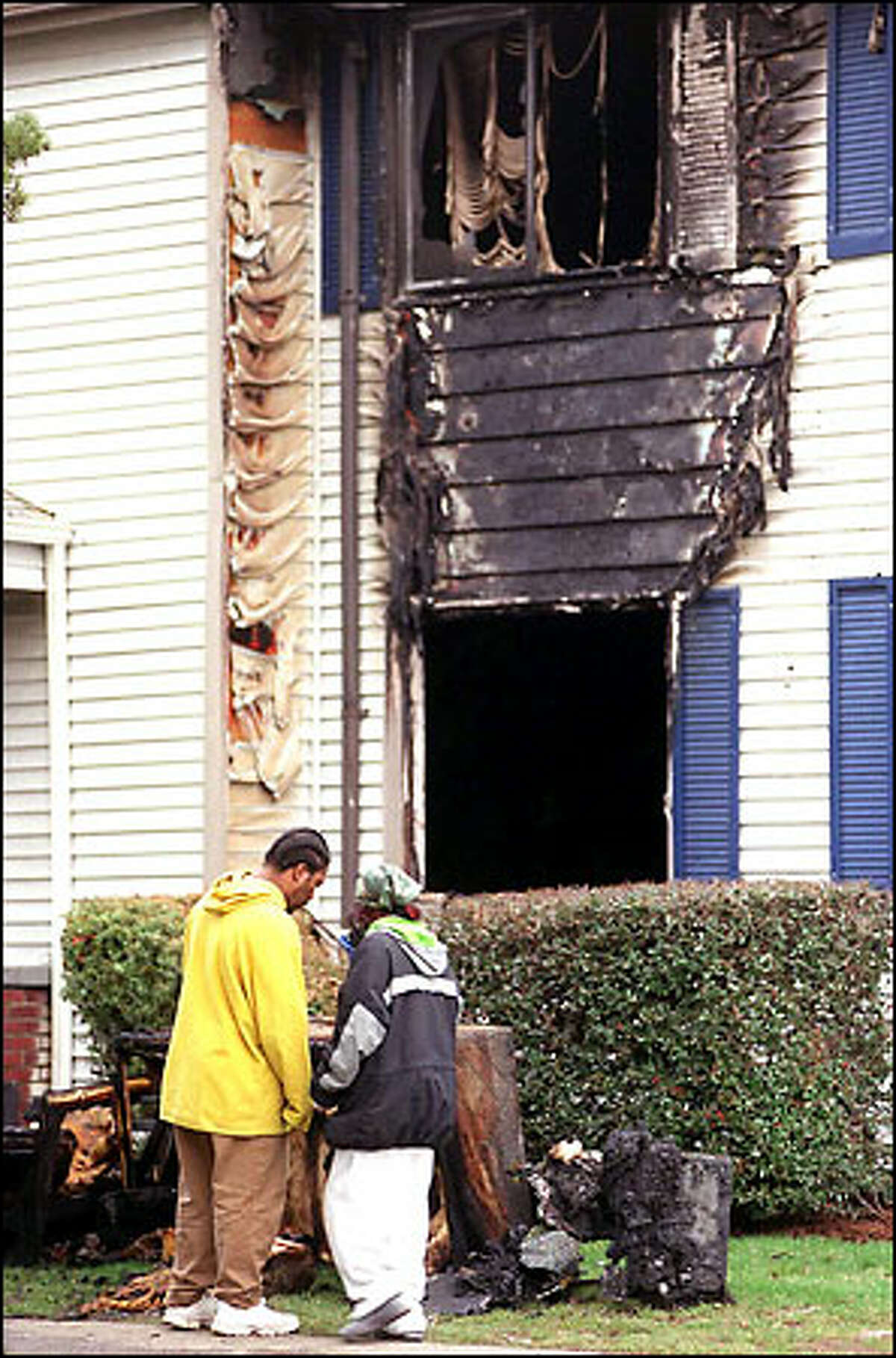 Residents of the Vintage Park apartments look over the aftermath of a fire in the Burien complex yesterday morning. More than 30 people were forced to evacuate, but housing was found for them. No injuries were reported.