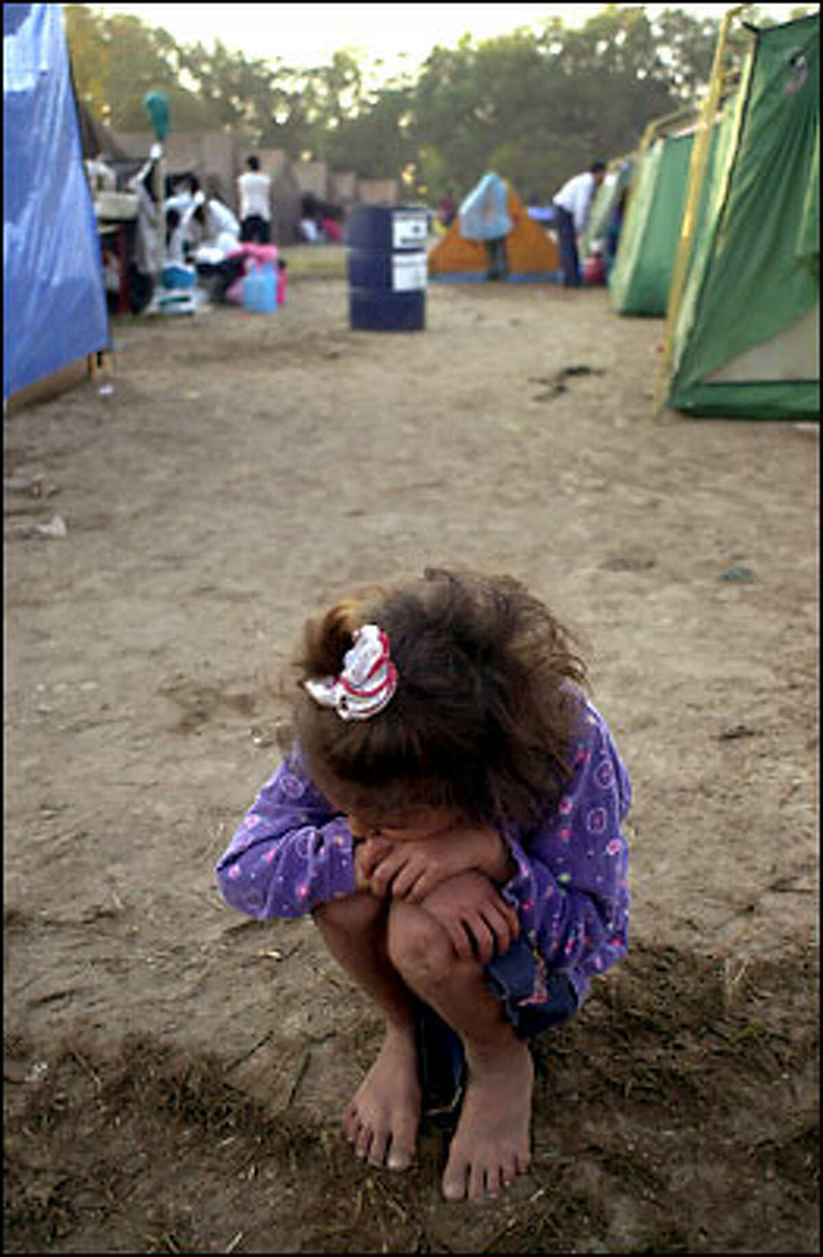 A child crouches in a camp for people made homeless by last Saturday's earthquake in El Salvador that killed nearly 700 people. Many of the survivors remain traumatized.