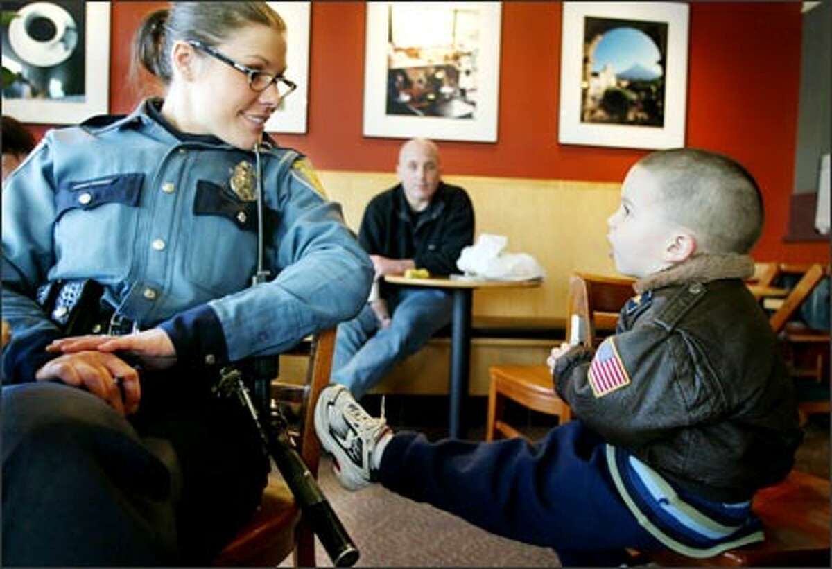 Officer Daina Boggs talks to Jack Durham, 4, at a Starbucks in West Seattle as dad, Matt Durham, watches. Boggs will move to the Southwest Precinct when it opens.