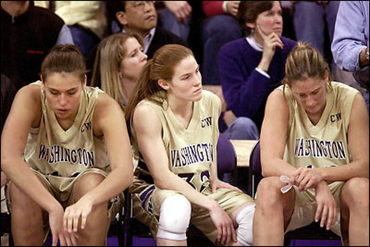 Washington players, from left, Andrea Lalum, Jill Pimley and LeAnn Sheets, sit dejectedly as time runs out in their loss to Oregon in Bank of America Arena.