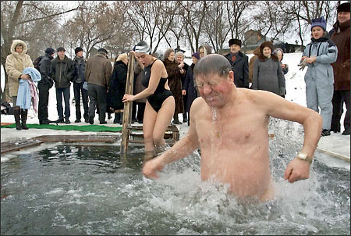A man emerges a hole in the ice of the Moscow River -- the water was about 41 degrees -- after it was blessed by an Orthodox priest on Epiphany in the village of Ilyinskoye, near Moscow. Thousands of Russian Orthodox Church members plunged into icy rivers and ponds today to cleanse themselves with water deemed holy for the day.