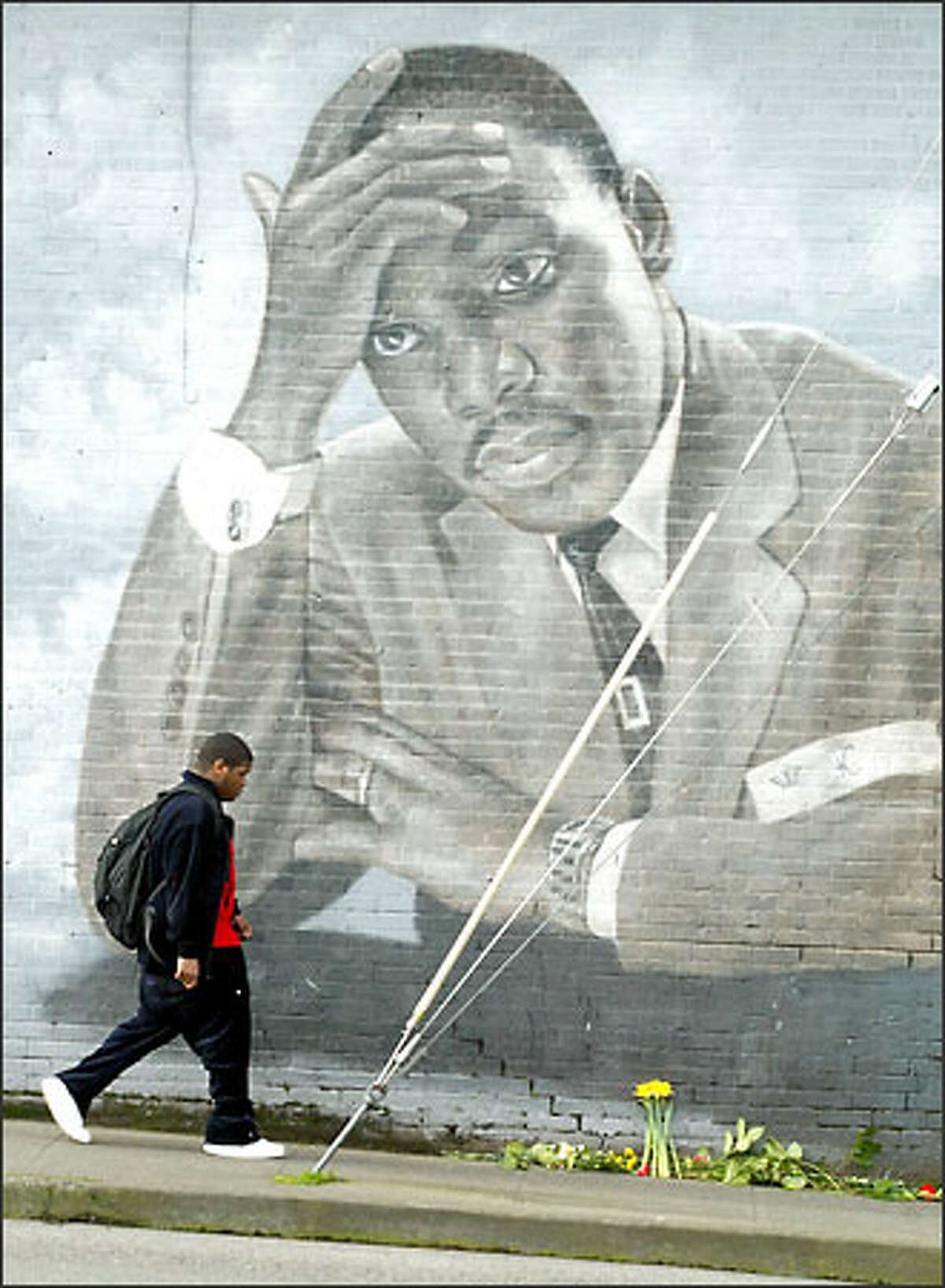 In commemoration of King's birthday, schoolchildren brought flowers and notes addressed to the slain peace activist and placed them below the mural at the intersection of MLK Way East and East Cherry Street.