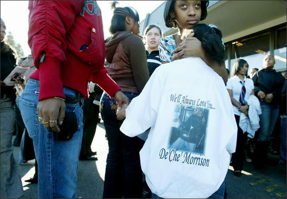 Jamazia Brown, 8, in a shirt in honor of her 14-year-old cousin De'Ché Morrison, holds the hand of her stepmother, Jimmia Brown, at Morrison's funeral Tuesday.