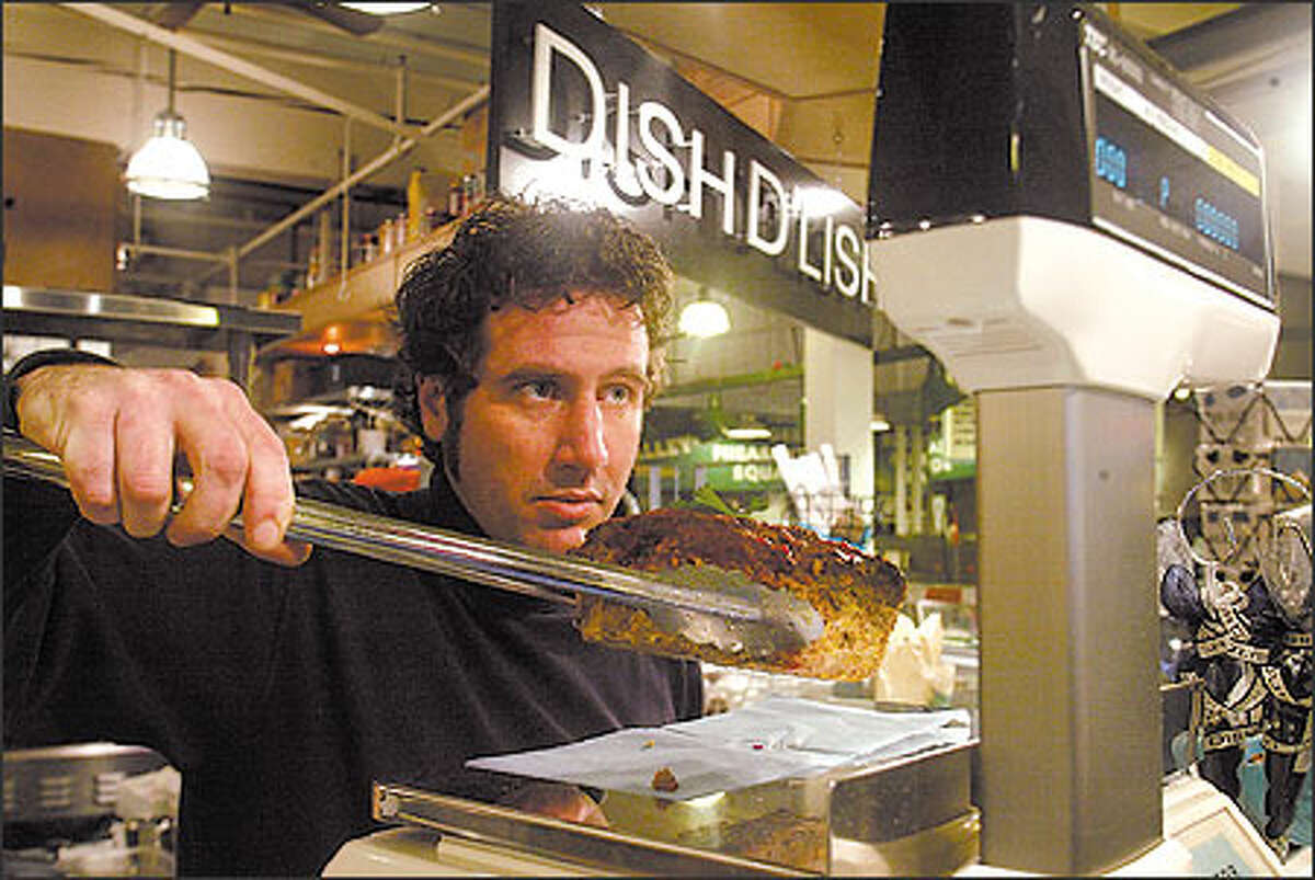 Counterman Daveed Yeast weighs a hunk of meat loaf for a customer at Kathy Casey's Dish D'Lish, which bills itself as "food t' go-go," in the Pike Place Market.