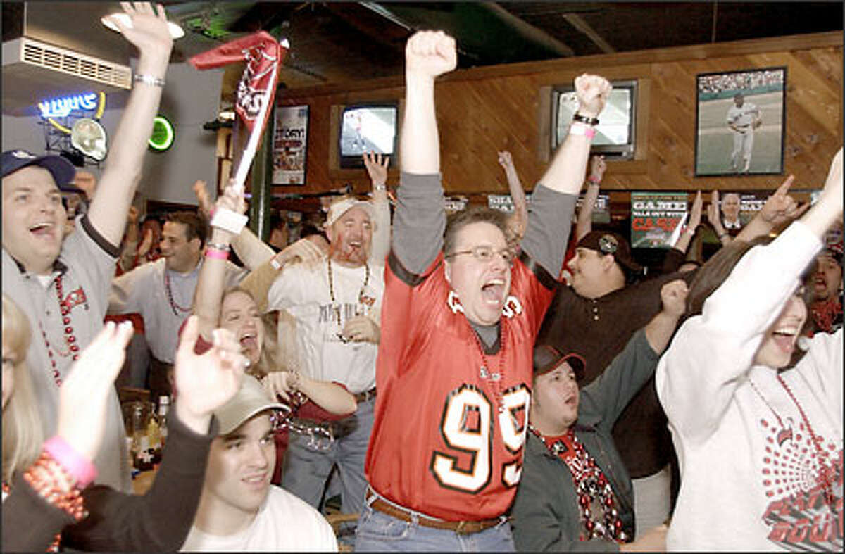 Tampa Bay Buccaneers fans celebrate as they watch their team score against the Oakland Raiders in the third quarter of Super Bowl XXXVII, at Beef O' Brady's sports pub in Tampa, Fla.