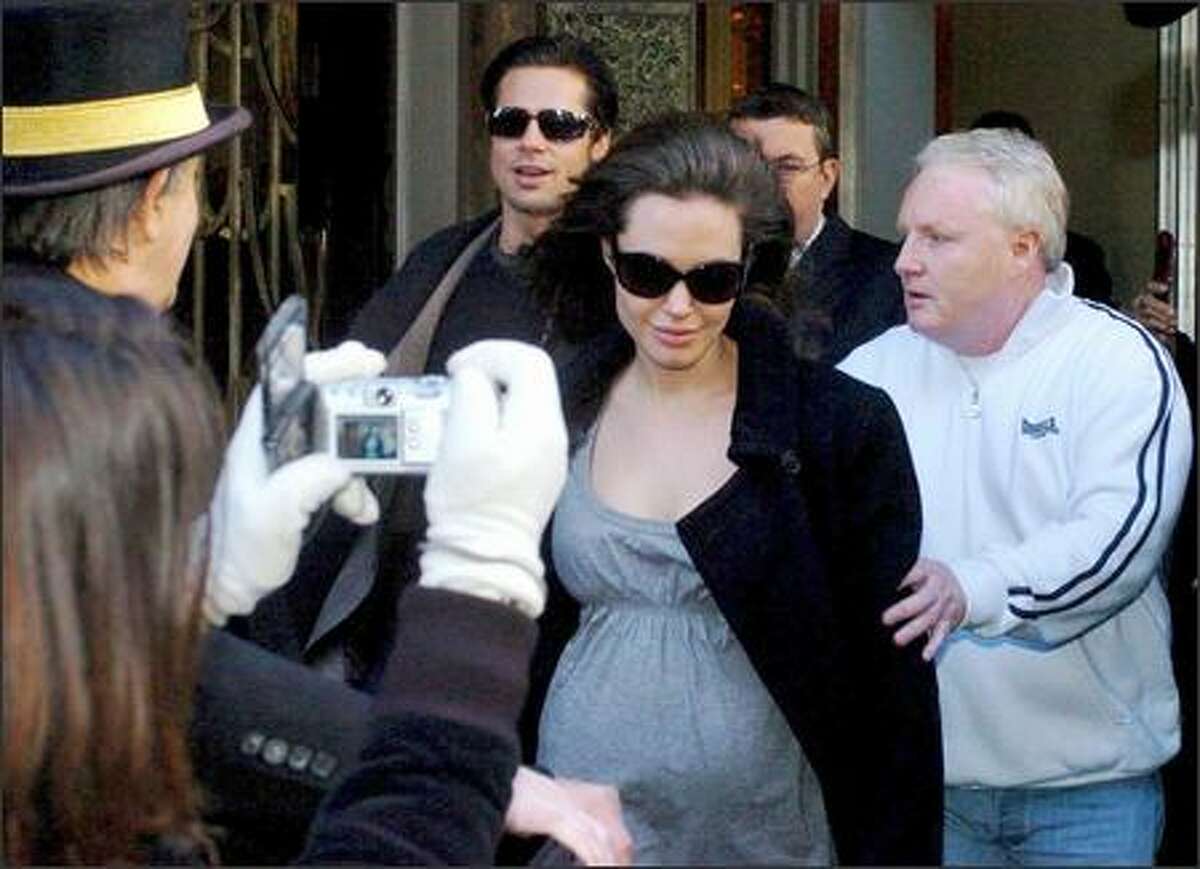 No question any longer that Angelina's tummy is in the expand-o mode, judging by this photo from London. Ms. Jolie & Mr. Pitt exit their hotel and head to the airport to join the throngs of power brokers and activist celebs gathered in Davos, Switzerland, for that annual romp known as the World Economic Forum.