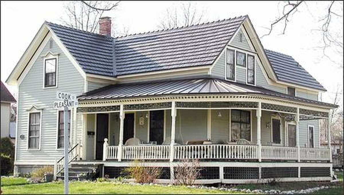 Installing a metal roof, such as this simulated cedar shake aluminum one on the main house and the standing seam roofing on the porch, can earn homeowners a tax credit of $500. (CLASSIC PRODUCTS)