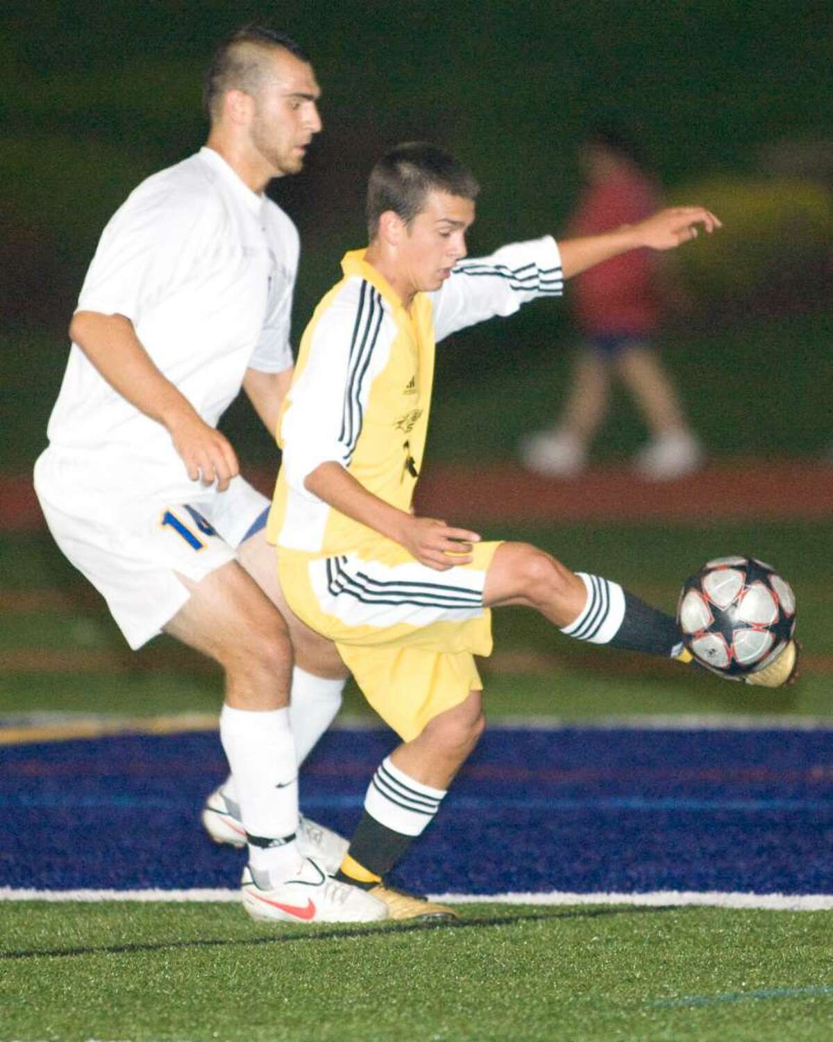 Dean Basak Smith of Joel Barlow gets a foot on the ball despite the tight marking of Brookfield's Chris Ackell Thursday night at Brookfield High.