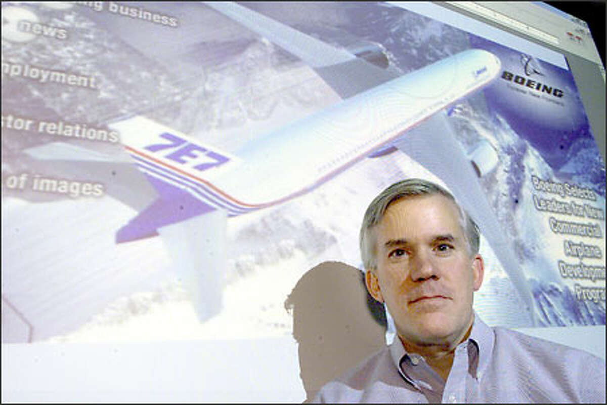 Mike Bair, senior vice president for Boeing's Commercial Aviation Services, stands in front of a computer-generated image of the proposed 7E7.