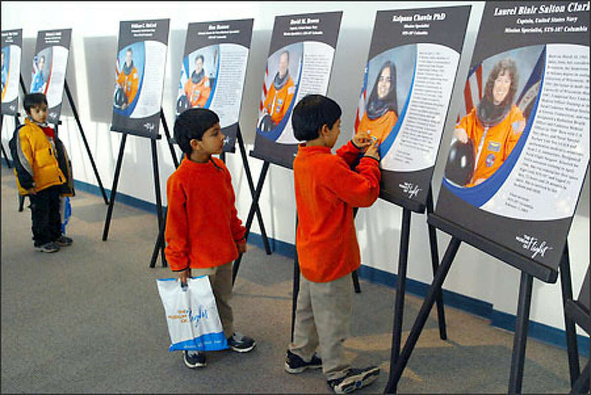Avi Parikh, 6, of Kirkland and his brother, Devon, 4, look at a photo of Kalpana Chawla, who died on the Columbia space shuttle, at the Museum of Flight yesterday. Seven astronauts died in the Columbia tragedy during re-entry into the Earth's atmosphere last February.