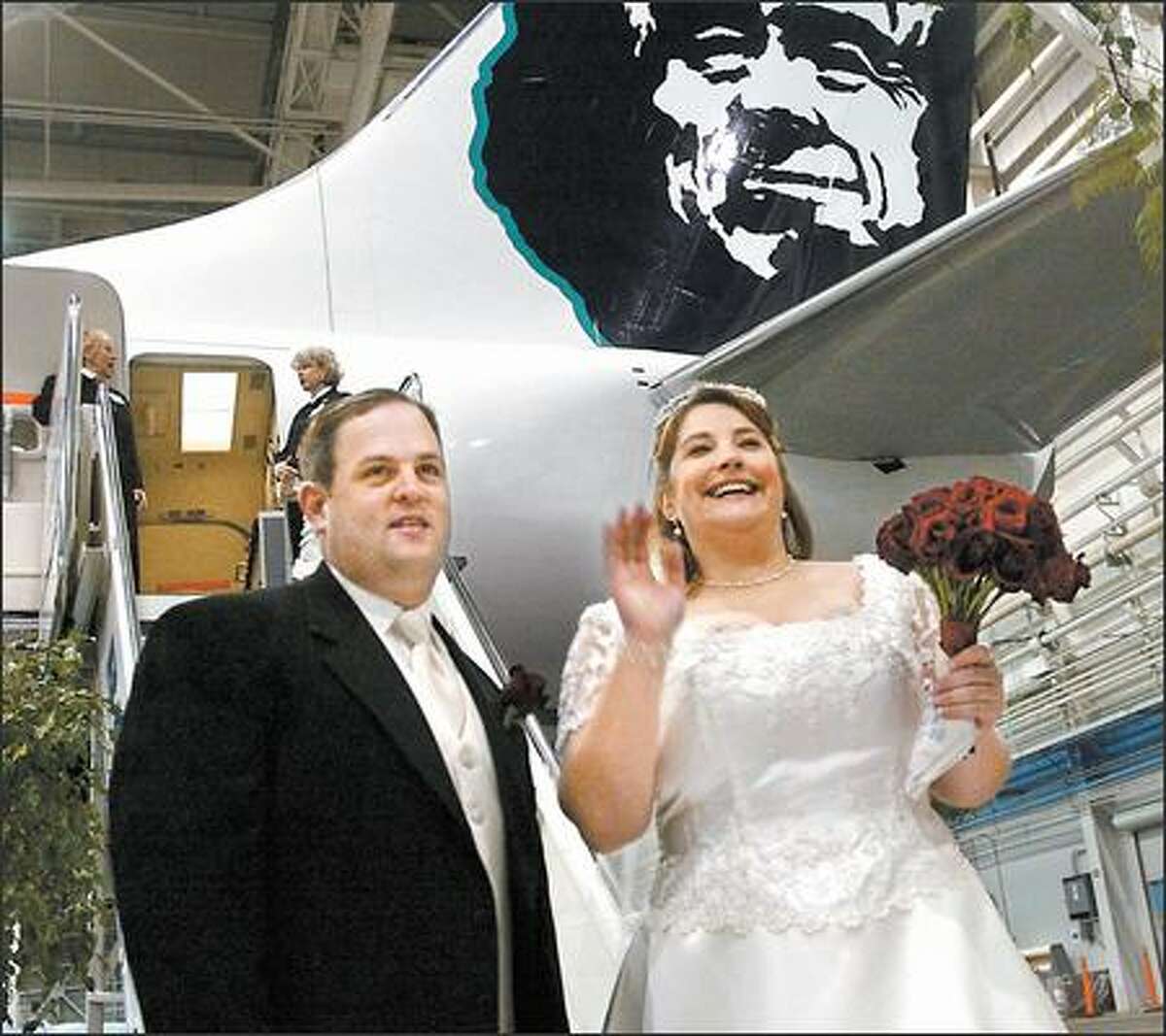 Alaska Airlines celebrated the delivery of its newest airplane, a Boeing 737-800, yesterday with an onboard wedding with employees Frank Raymond and Jennifer Genna. The plane departed from Boeing Field and touched down at Sea-Tac Airport. Raymond and Genna, shown here before boarding the airplane, planned to tie the knot over Mt. Rainier. Captain Mike Swanigan was the ceremony officiant, according to the couple’s wedding invitation. The card shows an Alaska Airlines jet flying through a heart made of red balloons.