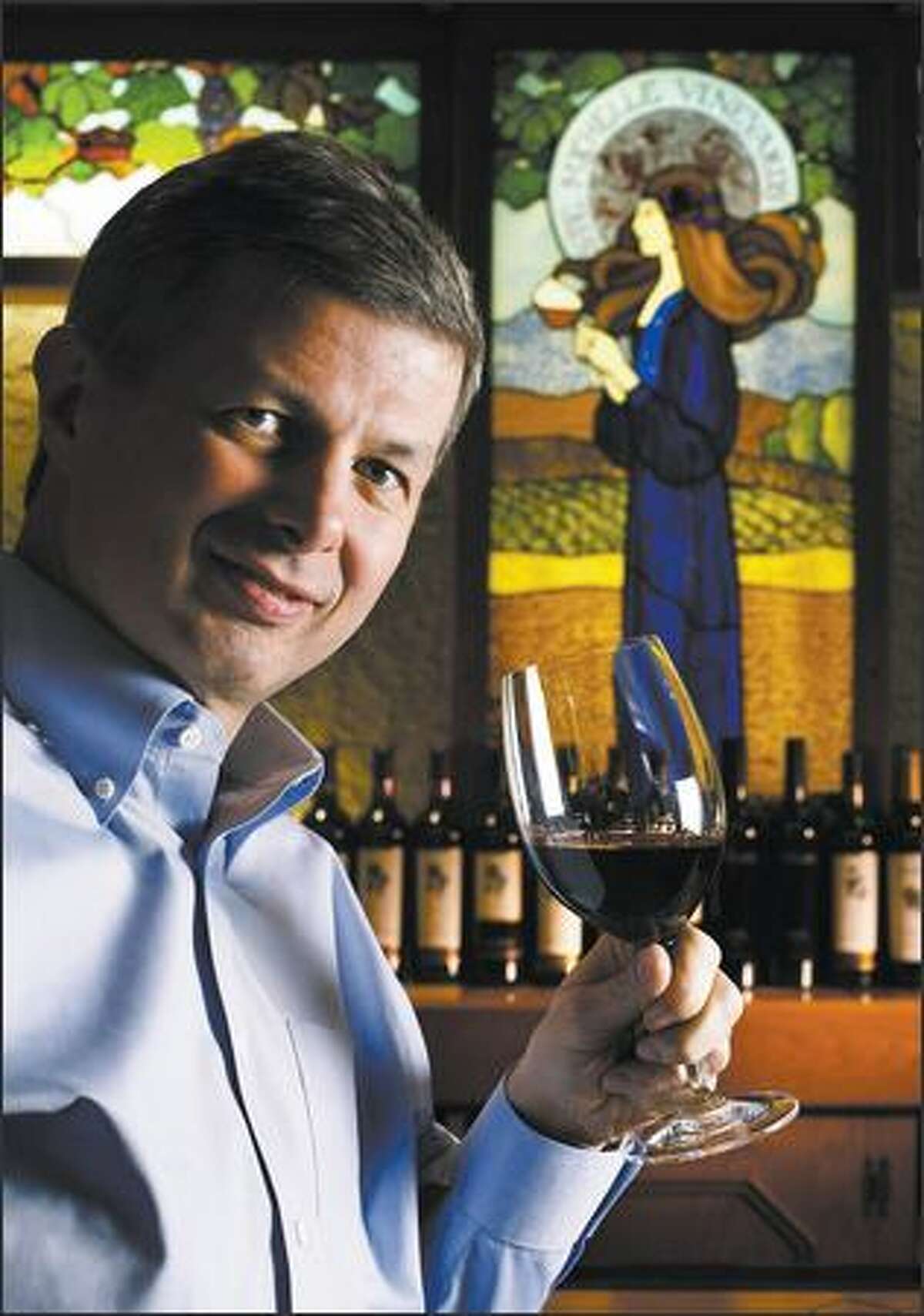 Ste. Michelle Wine Estates CEO Ted Baseler lifts a glass of 2004 Col Solare at a chateau tasting bar.