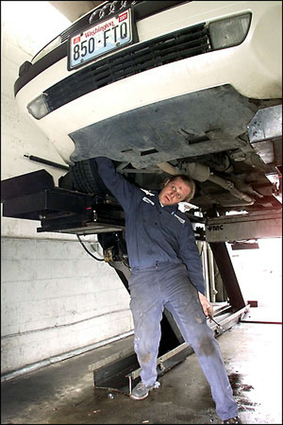Auto mechanic David Hanson keeps his eyes on a computer monitor while adjusting the alignment on a customer's car. Hanson graduated from King County's drug court in May 2000.
