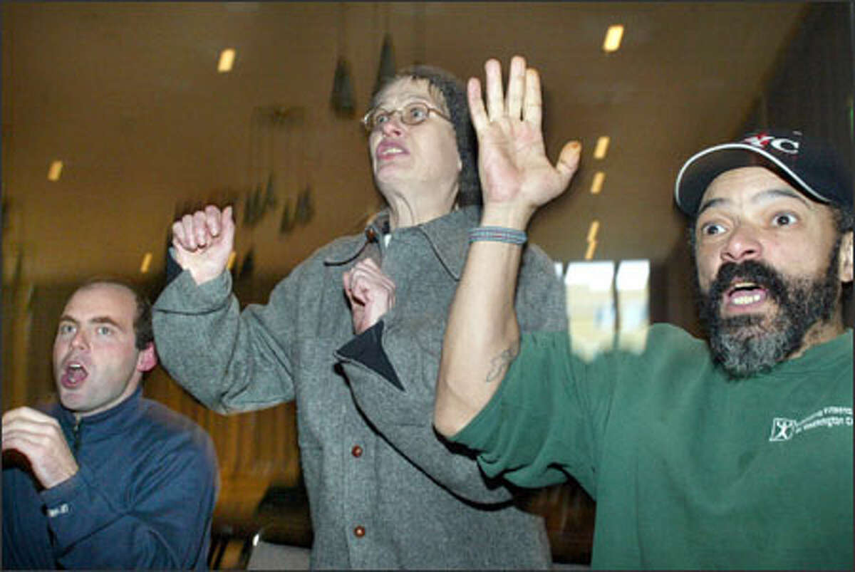 Tent City 3 residents Vicky, center, and Brian Huddleston, right, cheer for the Philadelphia Eagles, along with freelance reporter James Tulloch of Scotland.