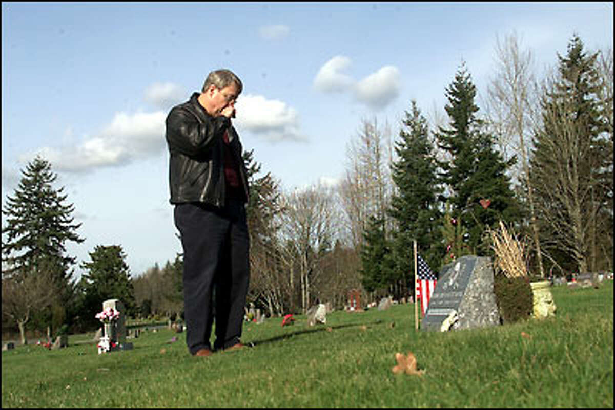 Frank King stands at the grave of his son Wade, who was killed in the 1999 Bellingham gas pipeline explosion. King is angry because the blast's precise cause is still unknown.