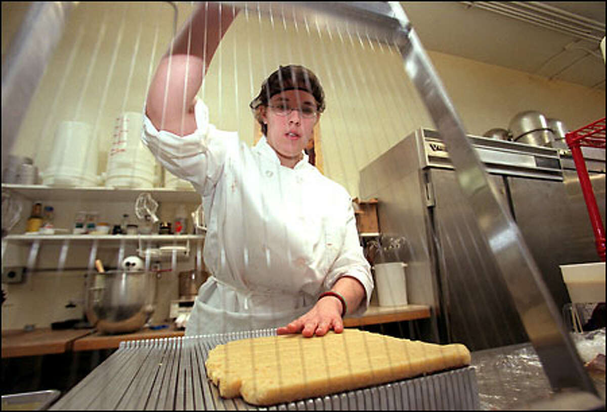 Anna Harlow slices orange marzipan at Fran's Chocolates in Seattle, whose products have caught the attention of some of the nation's top food writers.