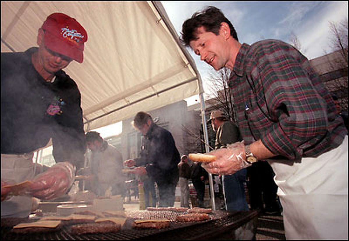 Mo Le Cleach, owner of the Planet Georgetown Restaurant, and Blazenko Kokorovic cook burgers for SPEEA workers at The Boeing Co.'s corporate headquarters in Seattle. The company's engineers, members of the Society of Professional Engineering Employees in Aerospace, were celebrating the one-year anniversary Friday of their first major strike.