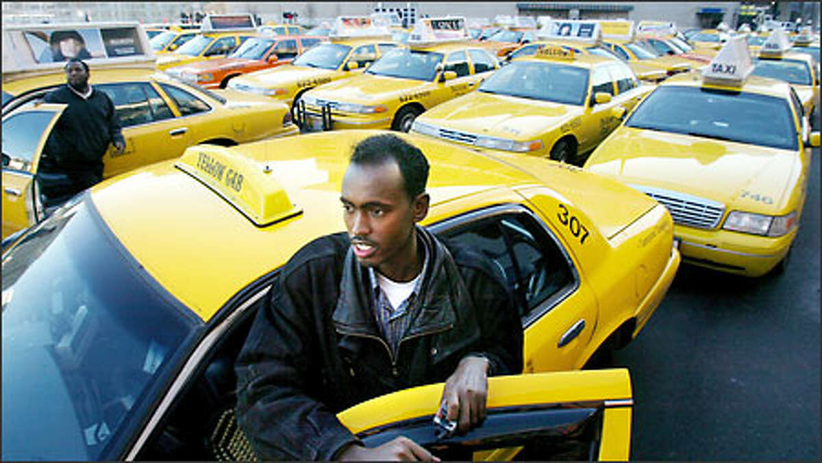 Said Fatah, a Yellow Cab driver for four years, stands by his taxi as drivers congregate on Occidental Avenue South near Seahawks Stadium before moving downtown yesterday.