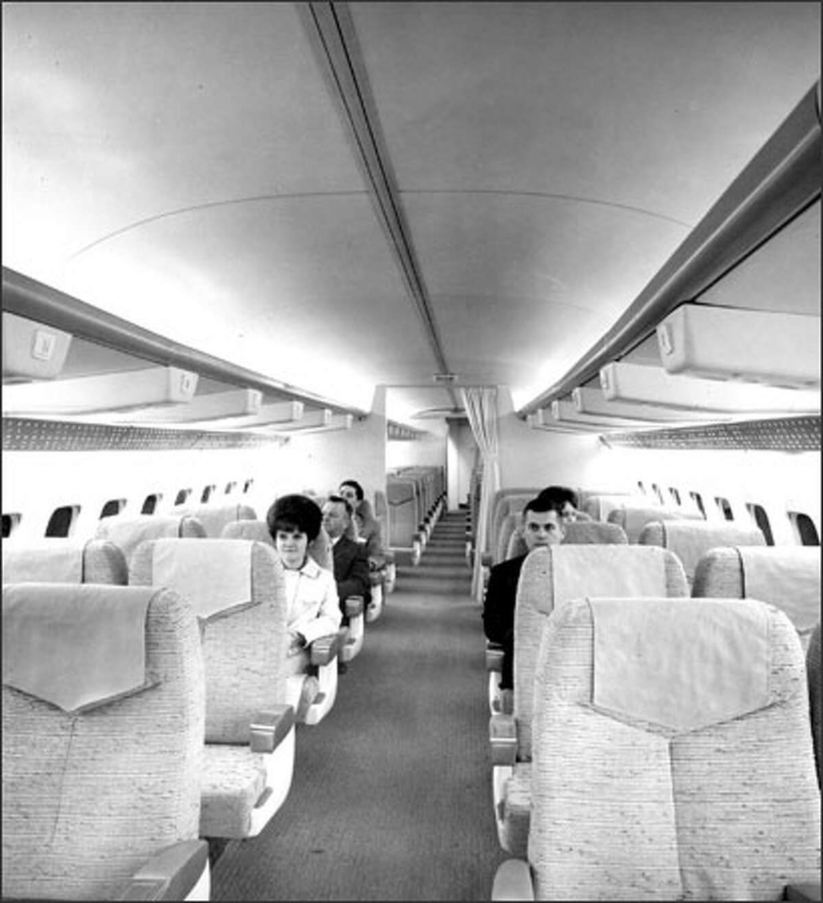 Boeing employees sit in the first-class section of a sales mockup of the 737 jetliner, about a year before the 737's maiden flight.