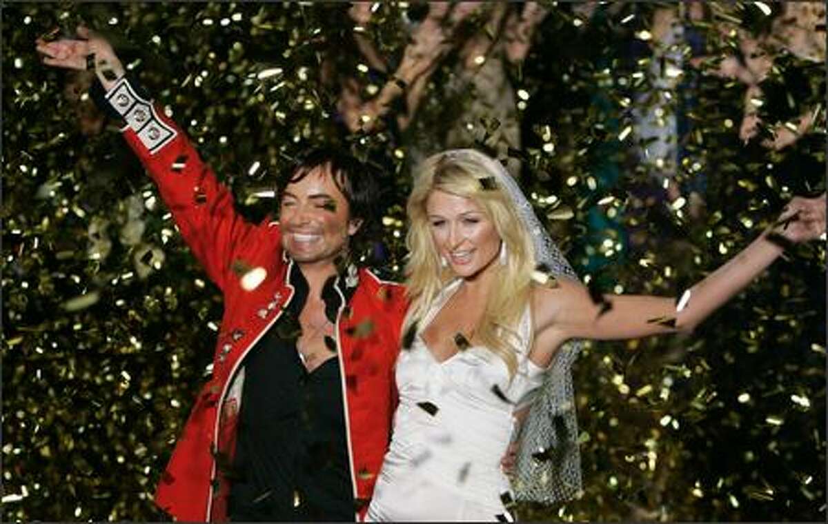 Calm smiles before the storm, flour-bomb division. The unavoidable Paris Hilton and Brit designer Julien MacDonald bask on stage following the preview of his new collection during London Fashion Week. Minutes later, the two beautiful people were doused with flour by reps of People for the Ethical Treatment of Animals to protest MacDonald's continued use of demon fur in his designer duds.