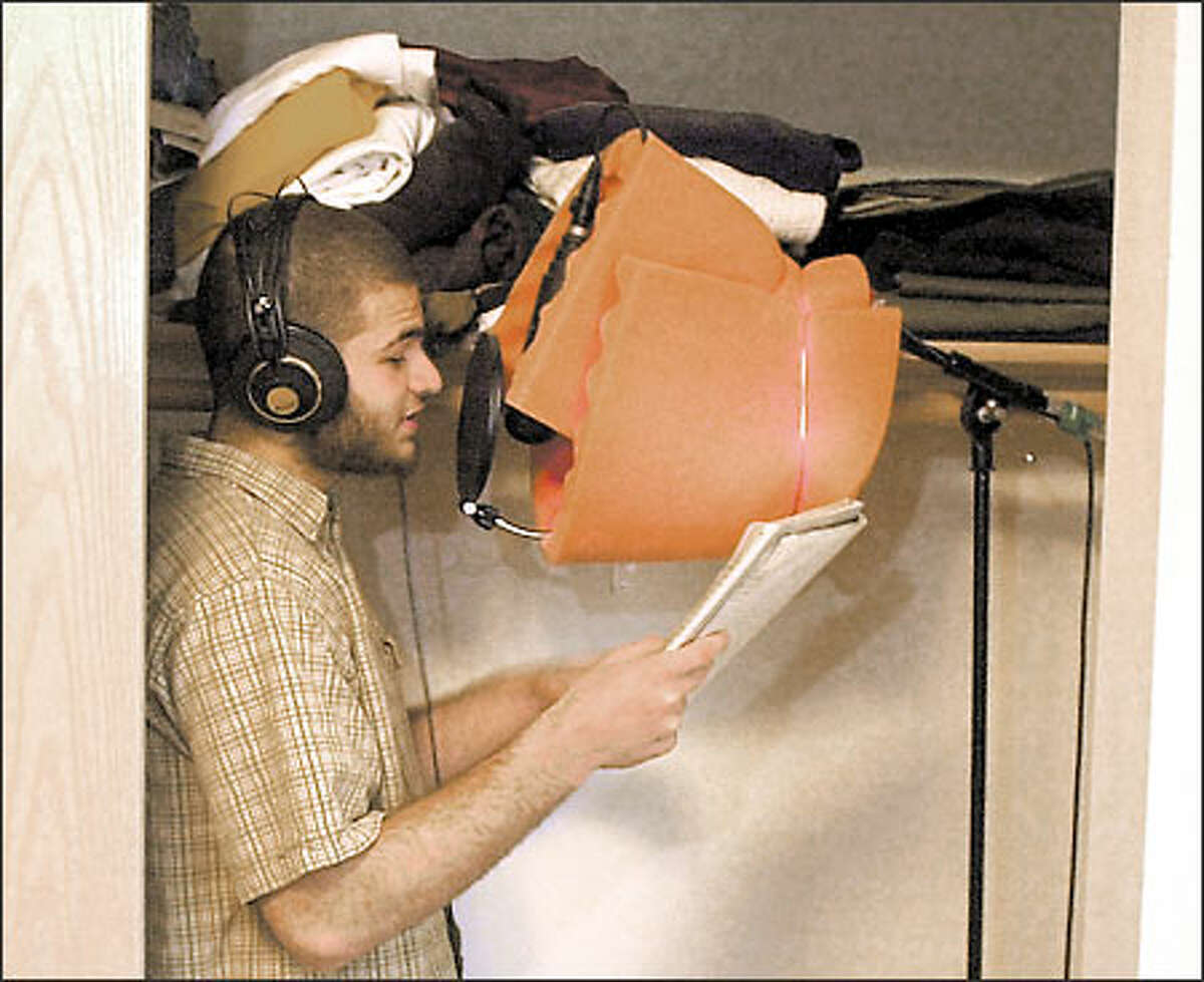 Abdul, 18, sings into a microphone in his bedroom closet during a recording session.