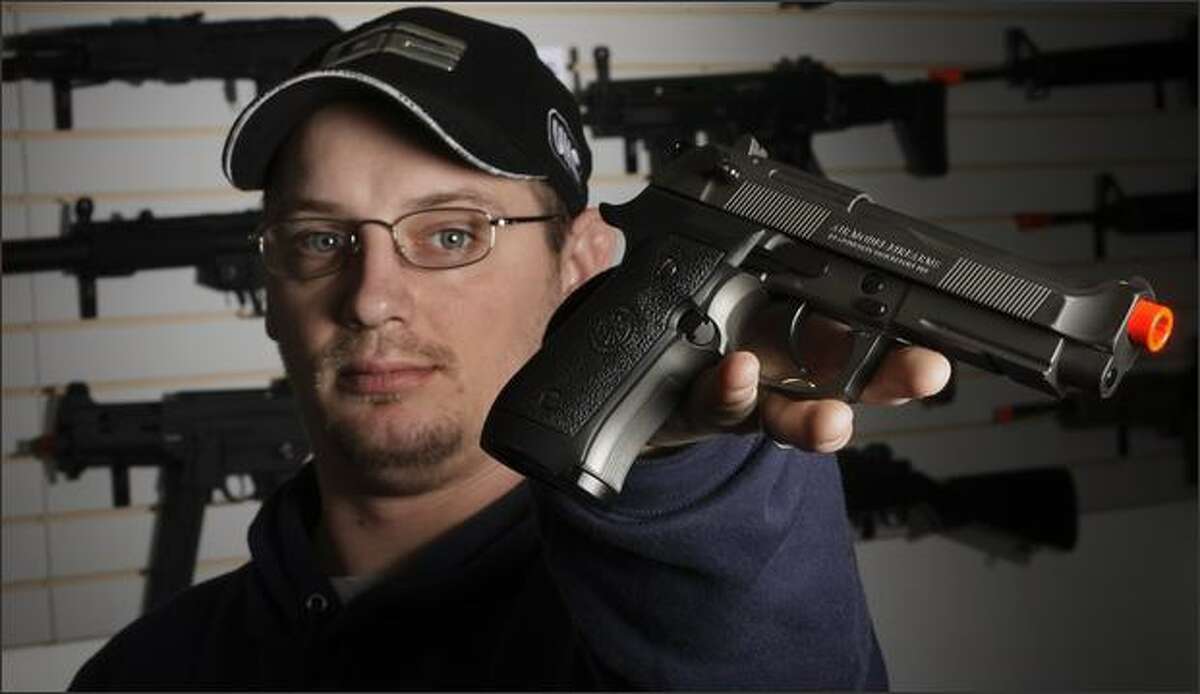 Jason Pfingsten, owner of Pacific Rim Airsoft in South Seattle,shows a Airsoft semi-automatic pistol designed to look like a real Beretta.