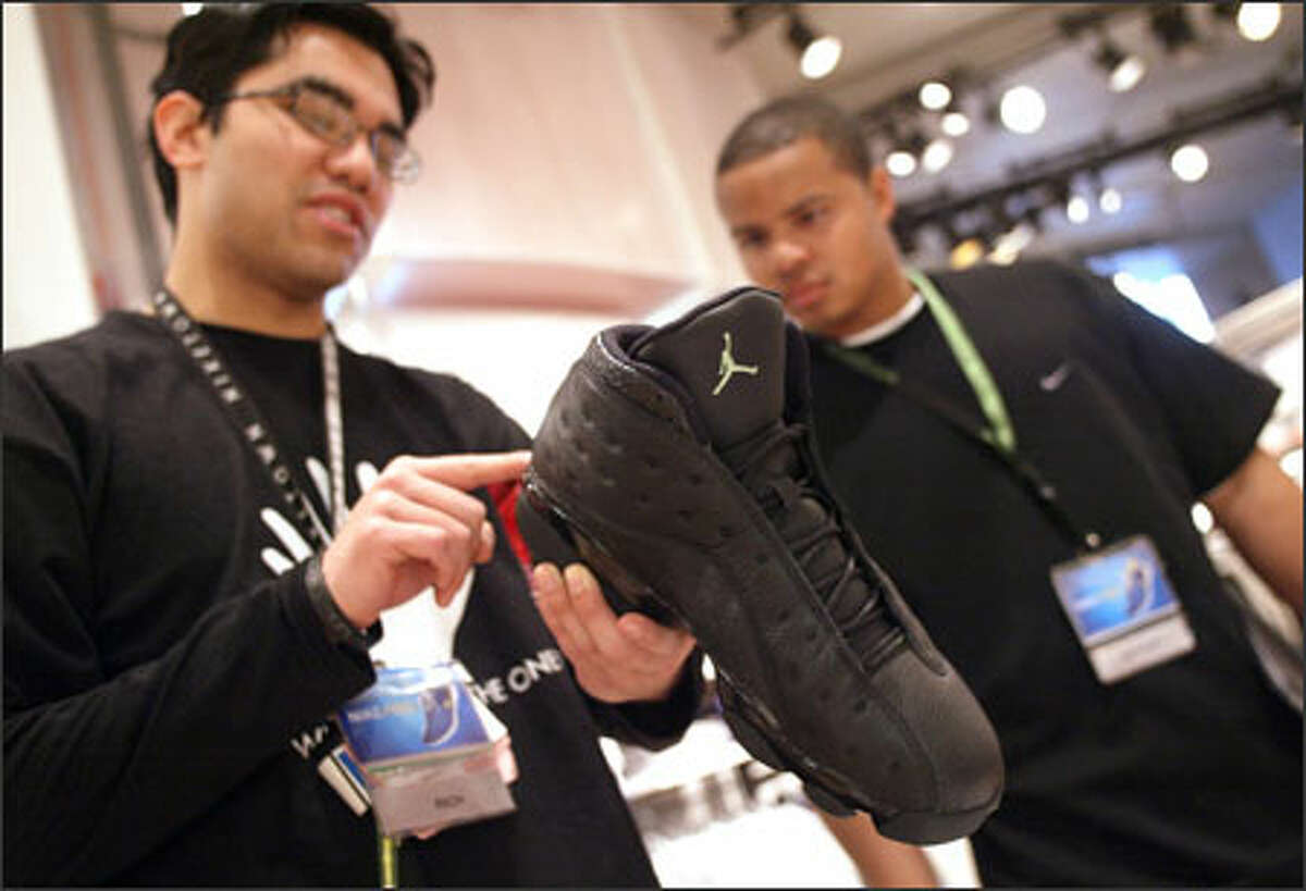 Sales clerks Rich Reyes, left, and Dominique Pie check out one of the Air Jordan Retro 13 shoes at Seattle's Niketown, which will sell only 60 pairs.