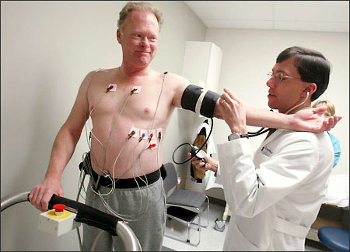 Dr. Tom Amidon checks Ken Schwarz's blood pressure. Schwarz is part of an experiment using gene therapy to regrow blood vessels in the heart.