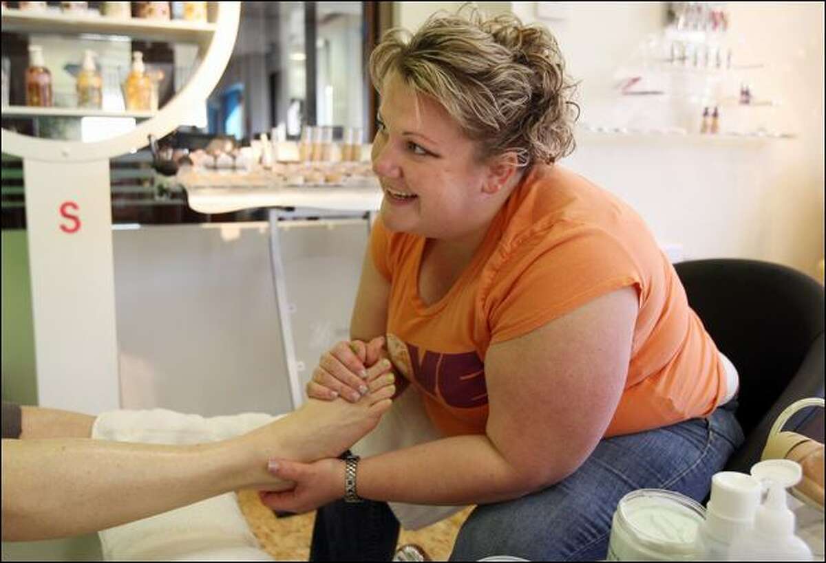 Beautician Heather Wood performs a pedicure for a client at the Caritta Salon in Boise, Idaho. Wood sometimes trades services for what she needs.
