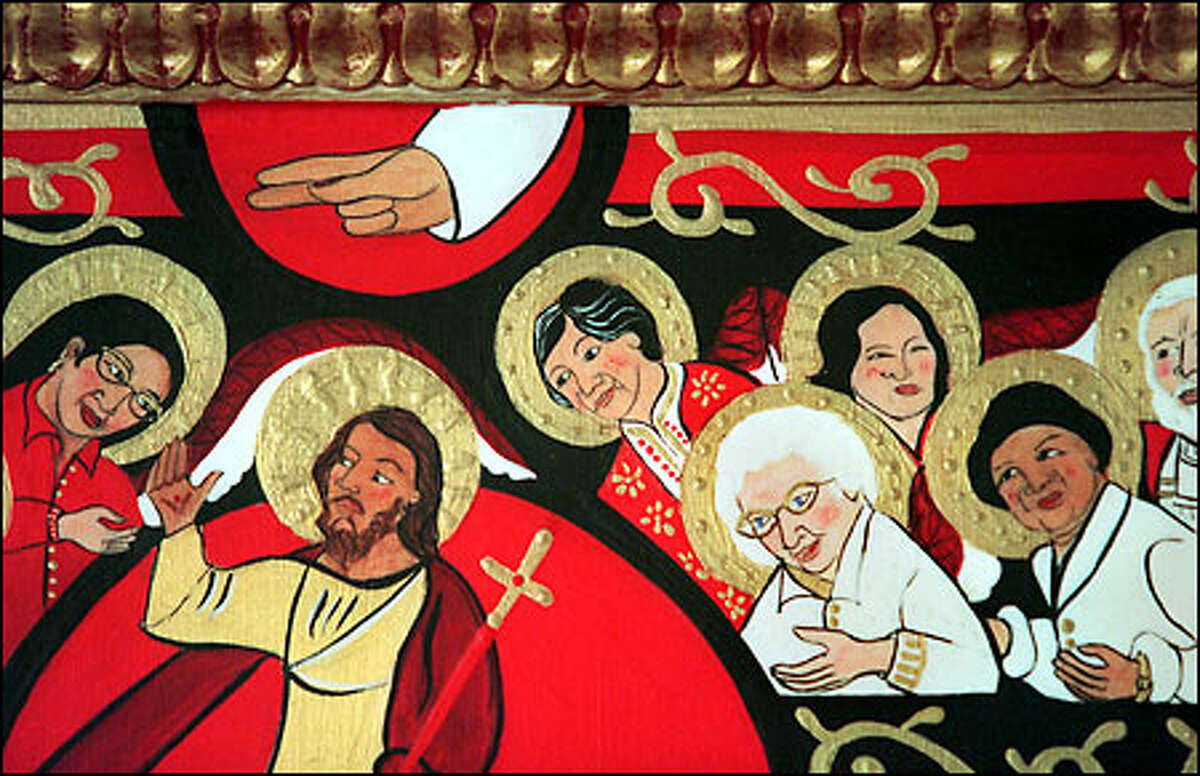 This closeup of the San Damiano cross shows the painted version of Alice Fadul standing behind the white-haired Demetria. The cross was painted by Seattle resident Christina Miller.