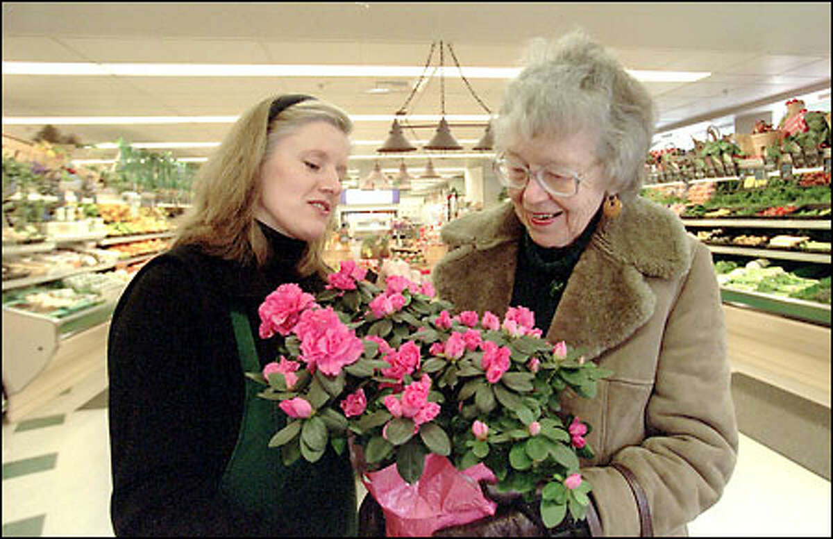 Polly Clark, right, shows Lillian Cawdrey, co-owner of Fremont Fresh Market, an azalea she is buying for a friend.