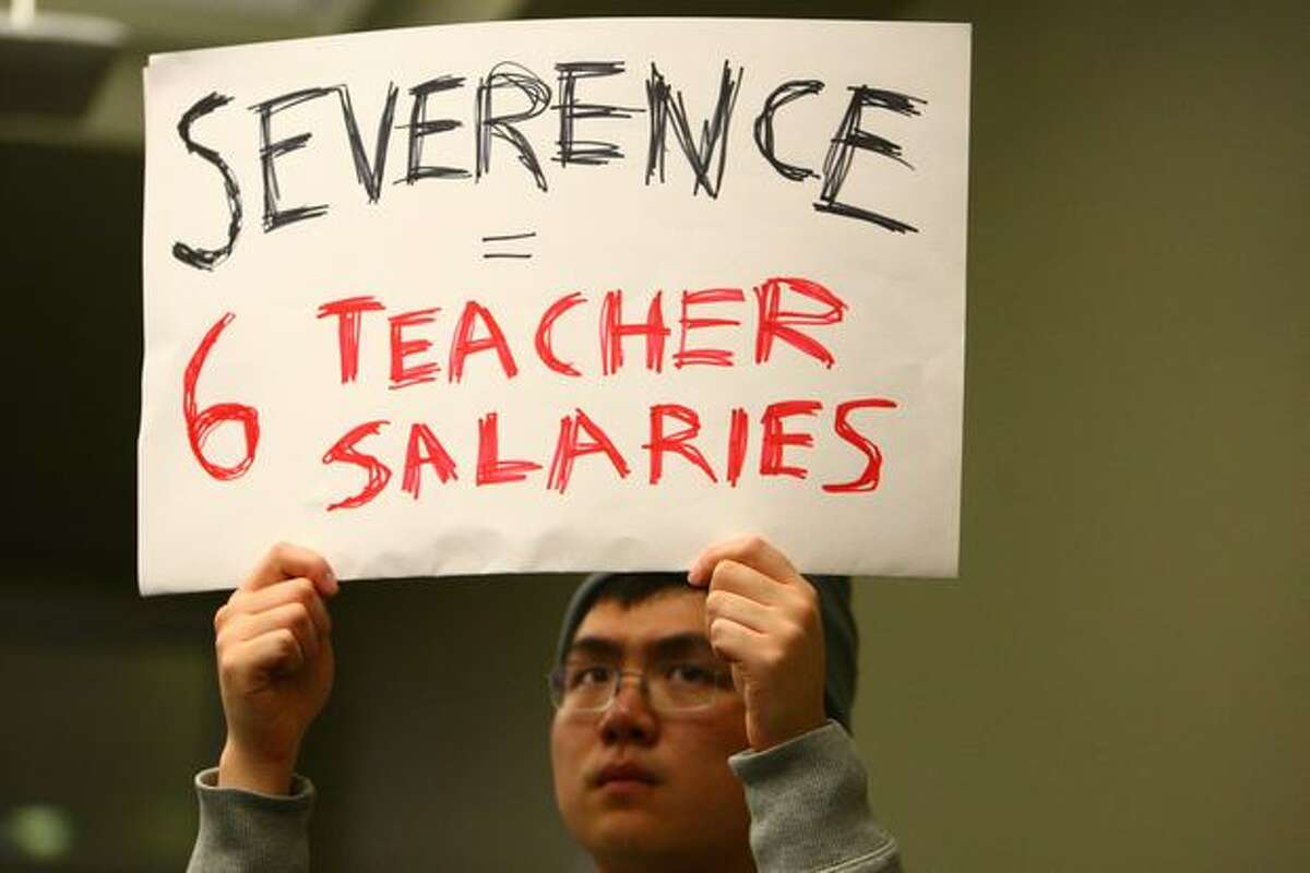 Johnny Mao holds a sign during a meeting of the Seattle Public School Board of Directors at the John Stanford Center for Educational Excellence in Seattle on Wednesday. The directors voted to terminate the employment of Superintendent Maria Goodloe-Johnson after revelations about a contracting scandal.