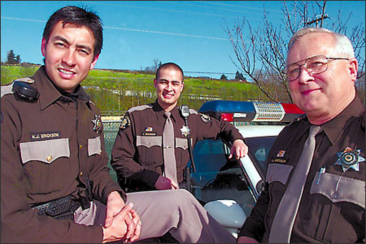 From left, Deputy Kraig Erickson, younger brother Deputy Leigh Erickson and their father, Sgt. Larry Erickson, are shown recently at the King County Sheriff's Office special operations headquarters near Boeing Field.