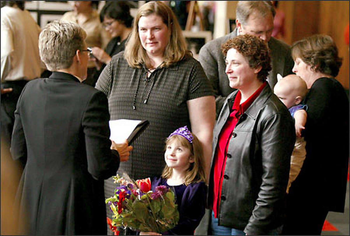 Karen Zeller Lane, left, and Janine Zeller Lane of Seattle, exchange wedding vows in Portland as their daughter DeLancey, 7, watches.