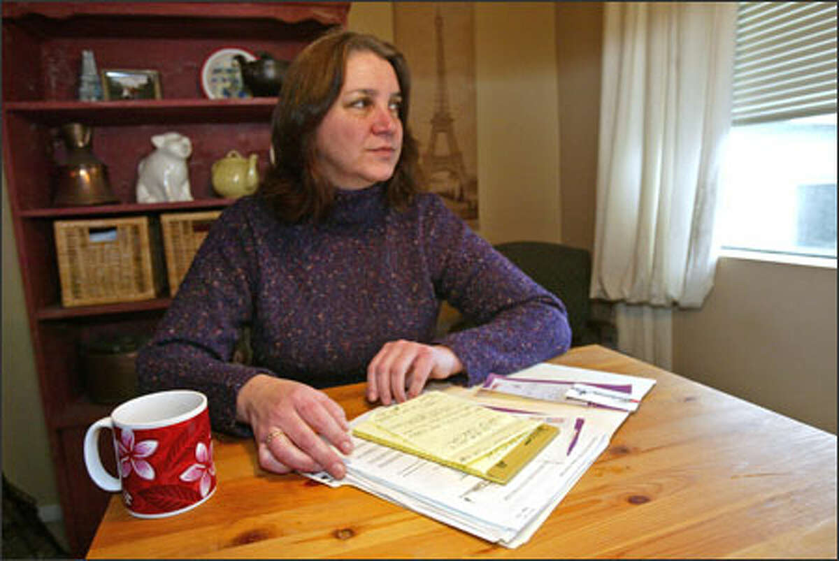 Janis Johnstone at her Edmonds home, with notes and papers pertaining to a deputy's run-in with her daughter, Stefanie.