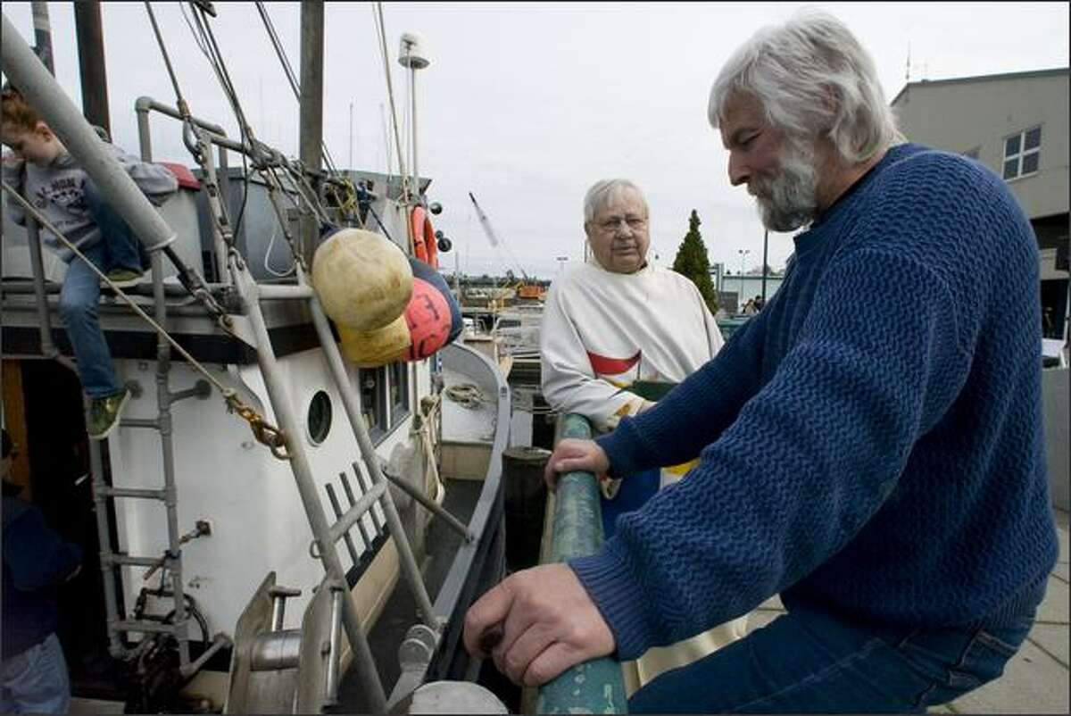 Pastor Emeritus Malcolm Unseth of Ballard First Lutheran Church, left, talks to Paul Mason, owner of the fishing boat Anita, Sunday at the Blessing of the Fleet.