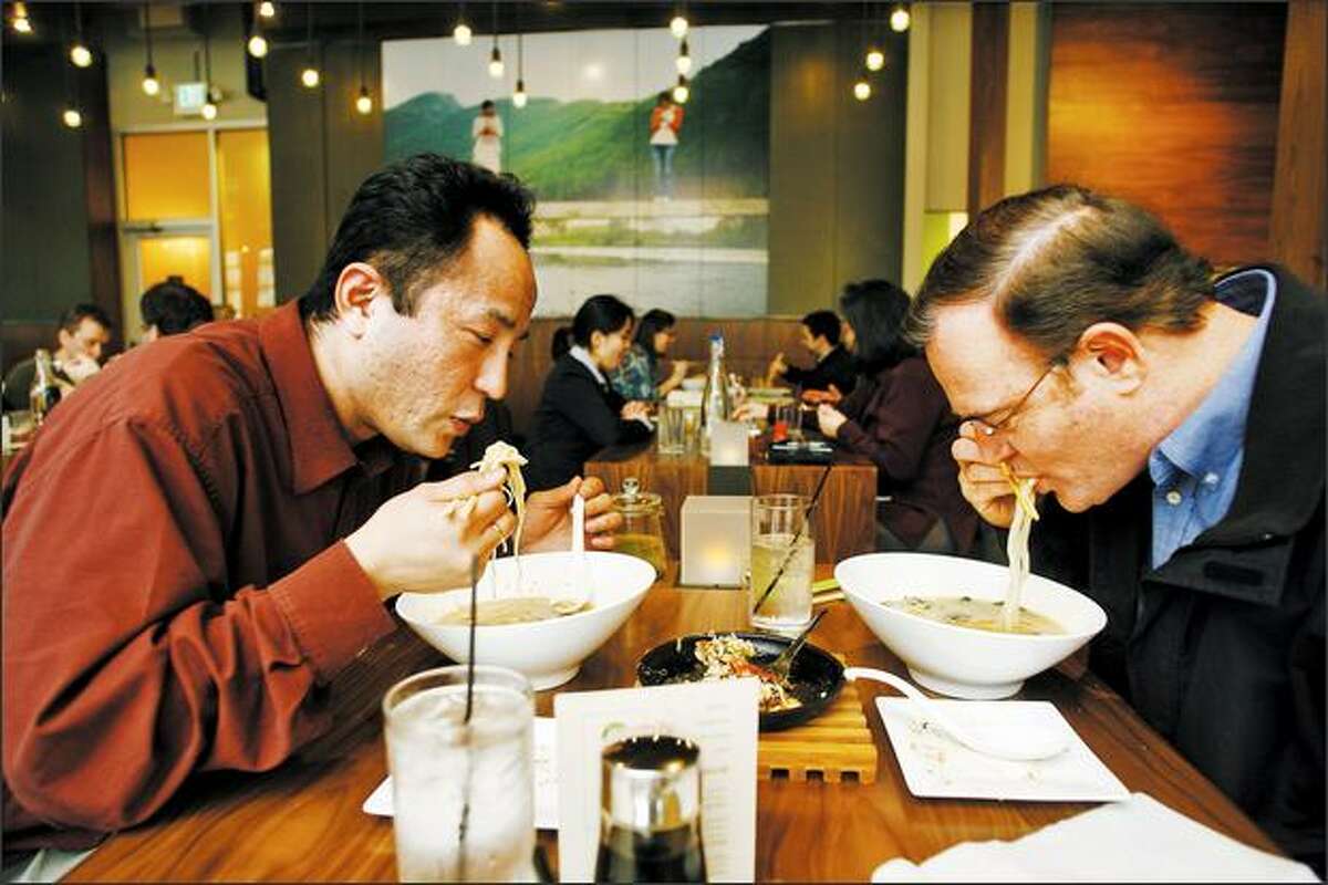 Masaki Miyagi and Michael Faris slurp their noodle lunches at Boom Noodle, which opened in January.