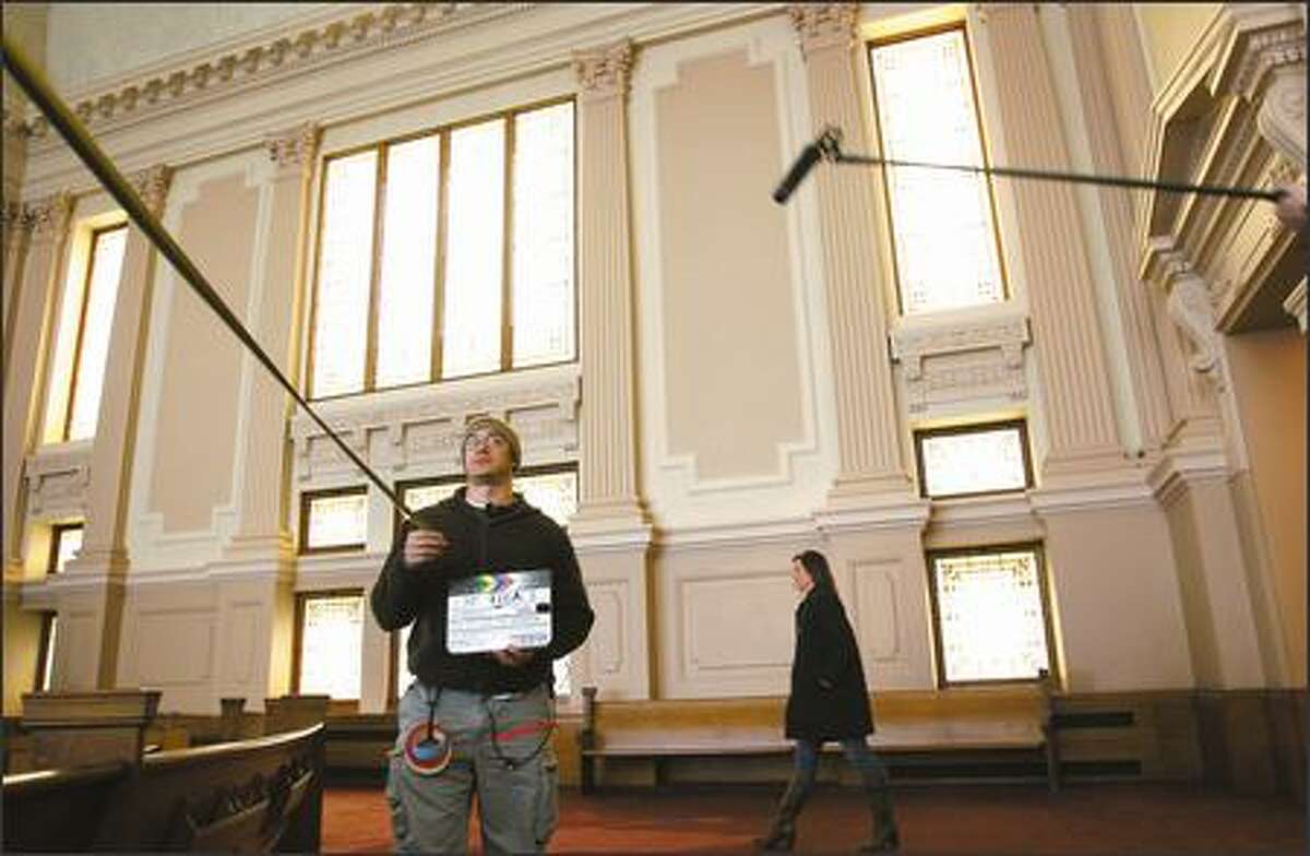 Nacime Khemis measures the camera distance while actress Elisabeth Rohm rehearses recently during filming of "The Spy and the Sparrow" at the First Church of Christ, Scientist, on Capitol Hill. Developers who are turning the sanctuary into condos delayed construction to allow the film crew to use the building.